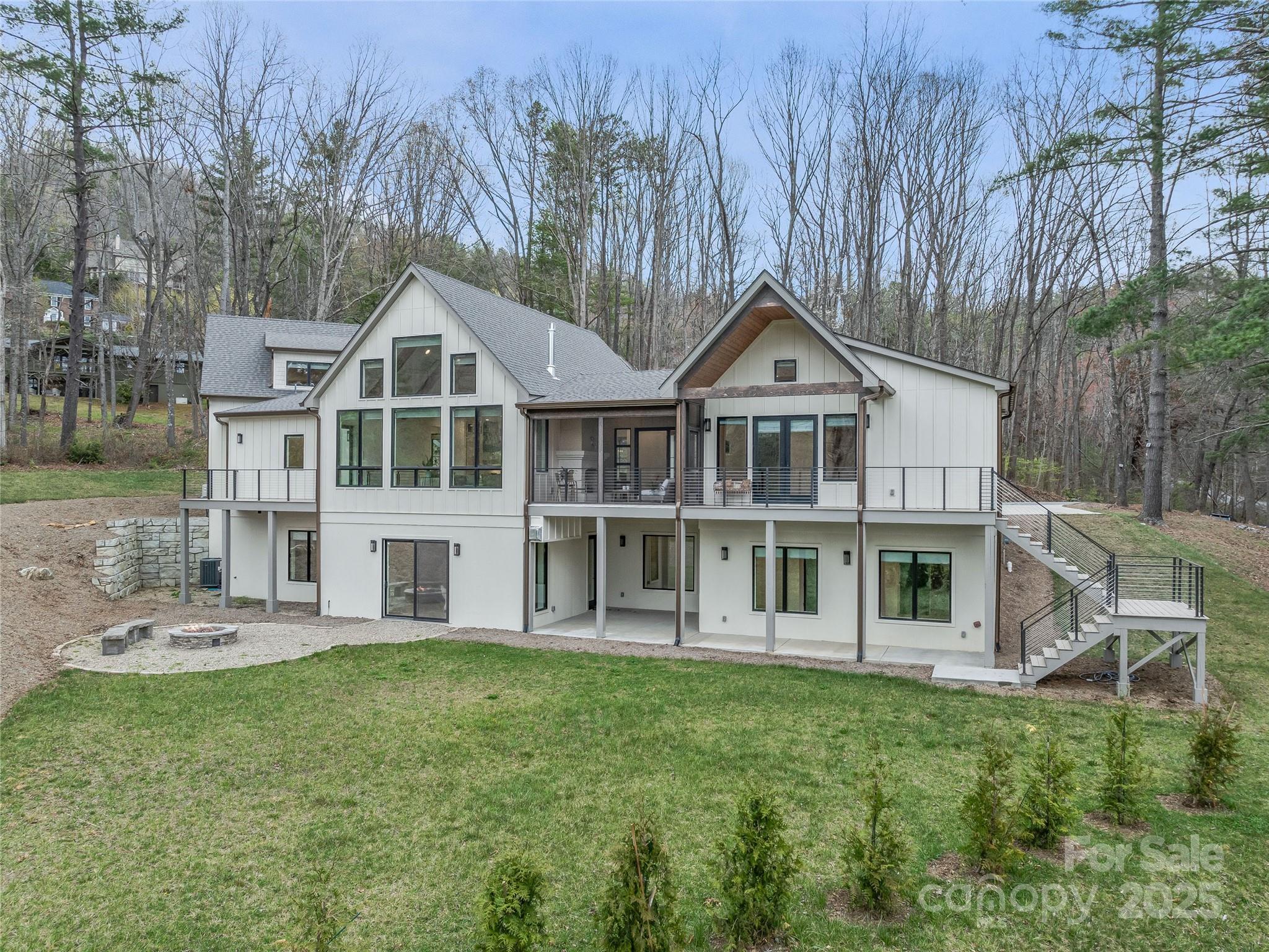 Modern farmhouse elegance meets refined mountain living in this custom-built, energy-efficient home perfectly sited on the 15th hole of the Country Club of Asheville. Located in coveted North Asheville, this designer residence features a chef’s kitchen with a quartz island and custom range hood, flowing into a vaulted great room with sweeping golf course and mountain views. The main-level primary suite offers a spa-inspired bath with a soaking tub and a spacious walk-in closet. A newly finished bonus room over the garage with a luxe full bath provides an ideal guest retreat, movie room, or private office. Thoughtful touches include a mudroom with built-ins, laundry, and a dog-washing station. Exceptional outdoor living consists of a screened porch with a gas fireplace, two decks, a lower patio wired for a hot tub, and a level backyard ready for a pool, garden, or play. Sophisticated, functional, and flawlessly designed.