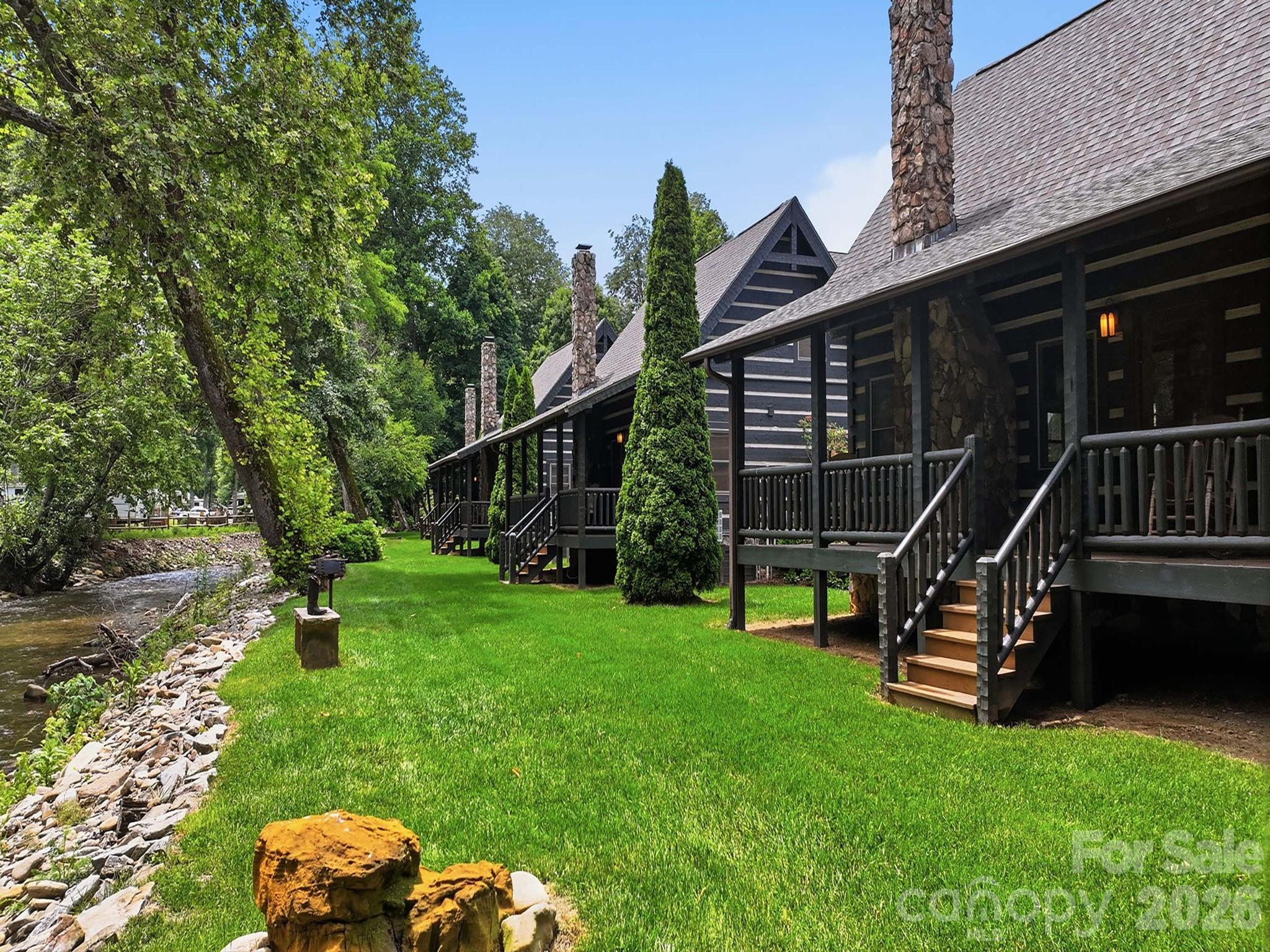 This two-bedroom, two full bath (with loft) was custom built by one of Western North Carolina's finest home builders, Scott Campbell.  Every detail of this authentic chink cabin has been thoughtfully curated.  Perched on the banks of Jonathan Creek in the Smoky Mountains of Maggie Valley, NC this could be your little slice of heaven. Sit on the porch and listen to the sounds of the creek or grab your fishing pole and try your luck at this famously stocked trout creek.  The community grill outside your door is perfect for gathering with friends and family while you enjoy grilling kabobs and taking a swim in the pristine mountain water.  This creek front dream getaway is being sold completely turnkey- sleeping six.  Pack your suitcase and come enjoy from day one.  The lock and go lifestyle is especially appealing as the HOA takes care of the landscaping allowing you to come and go freely without a care in the world.  Just a short golf cart ride to Maggie Valley Country Club- moments from award winning Downtown Waynesville voted #2 best downtown in America by USA Today.  40 Minutes to the Asheville Airport.  Located in valley- access is easy breezy- you and your guests will appreciate not having to take the switch back roads to a mountain top.  Maggie Valley appeals to year-round tourism with skiing in the winter, river rafting in the summer, horseback riding all year round.  Only 4 minutes to the Maggie Valley Fair Grounds where over 20 festivals are planned in 2026 alone- ranging from art and crafts to classic cars, bluegrass festivals, and more.  This is a solid investment any investor would appreciate!