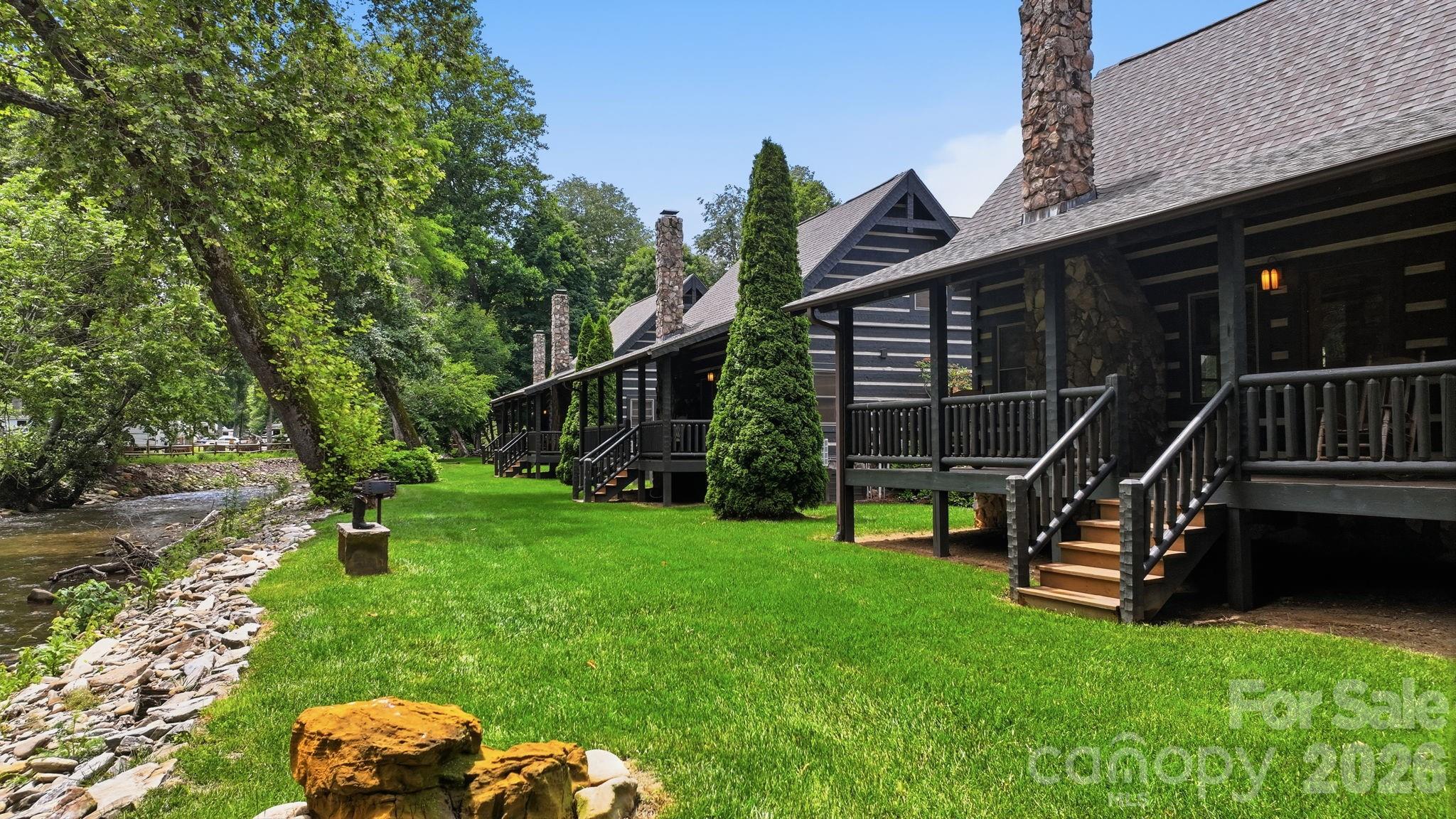 This two-bedroom, two full bath (with loft) was custom built by one of Western North Carolina's finest home builders, Scott Campbell.  Every detail of this authentic chink cabin has been thoughtfully curated.  Perched on the banks of Jonathan Creek in the Smoky Mountains of Maggie Valley, NC this could be your little slice of heaven. Sit on the porch and listen to the sounds of the creek or grab your fishing pole and try your luck at this famously stocked trout creek.  The community grill outside your door is perfect for gathering with friends and family while you enjoy grilling kabobs and taking a swim in the pristine mountain water.  This creek front dream getaway is being sold completely turnkey- sleeping six.  Pack your suitcase and come enjoy from day one.  The lock and go lifestyle is especially appealing as the HOA takes care of the landscaping allowing you to come and go freely without a care in the world.  Just a short golf cart ride to Maggie Valley Country Club- moments from award winning Downtown Waynesville voted #2 best downtown in America by USA Today.  40 Minutes to the Asheville Airport.  Located in valley- access is easy breezy- you and your guests will appreciate not having to take the switch back roads to a mountain top.  Maggie Valley appeals to year-round tourism with skiing in the winter, river rafting in the summer, horseback riding all year round.  Only 4 minutes to the Maggie Valley Fair Grounds where over 20 festivals are planned in 2026 alone- ranging from art and crafts to classic cars, bluegrass festivals, and more.  This is a solid investment any investor would appreciate!