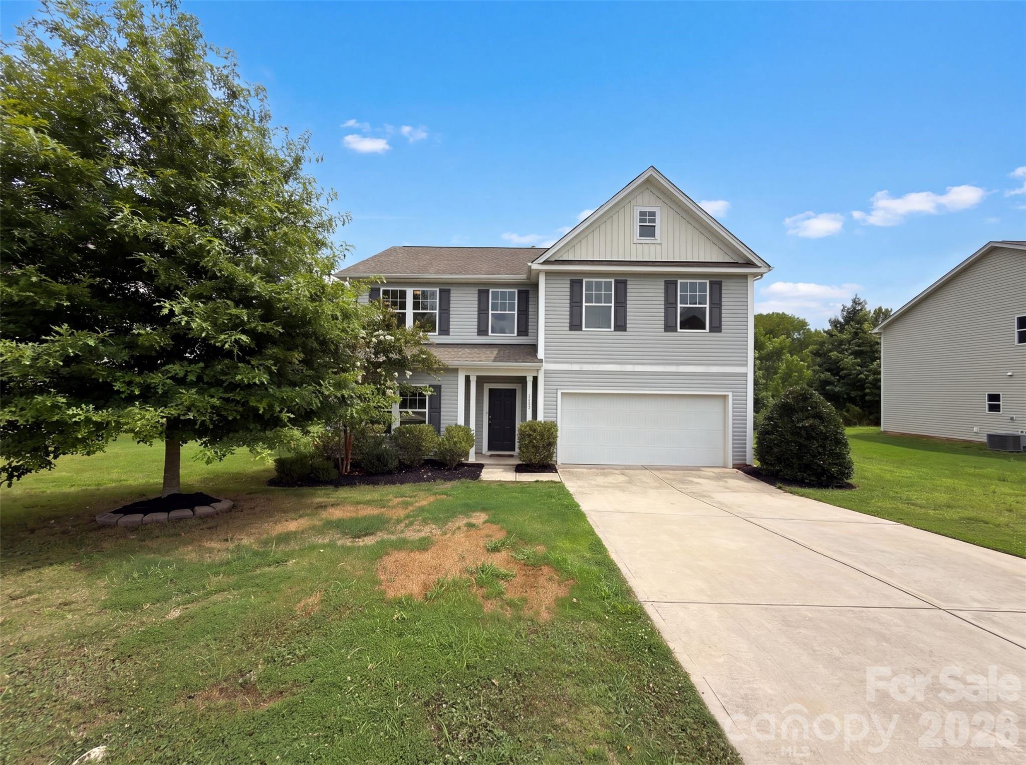 5627 Barclay Ct is a two-story Fort Mill home built in 2019 with a two-car garage and a rear deck. The kitchen features dark cabinetry, granite countertops, stainless steel appliances, and a center island, opening to a living and dining area with wood-look flooring. The main level stays bright and connected, with the kitchen overlooking the gathering space. Upstairs, carpeted bedrooms are well-proportioned, and the primary suite includes a bathroom with a double-sink vanity, a soaking tub, and a separate glass-enclosed shower. Additional full bathrooms serve the secondary bedrooms. Clean, neutral finishes carry throughout. Out back, the deck steps down to a grassy yard, extending the living space outdoors. The layout keeps shared and sleeping areas comfortably separated.. Included 100-Day Home Warranty with buyer activation