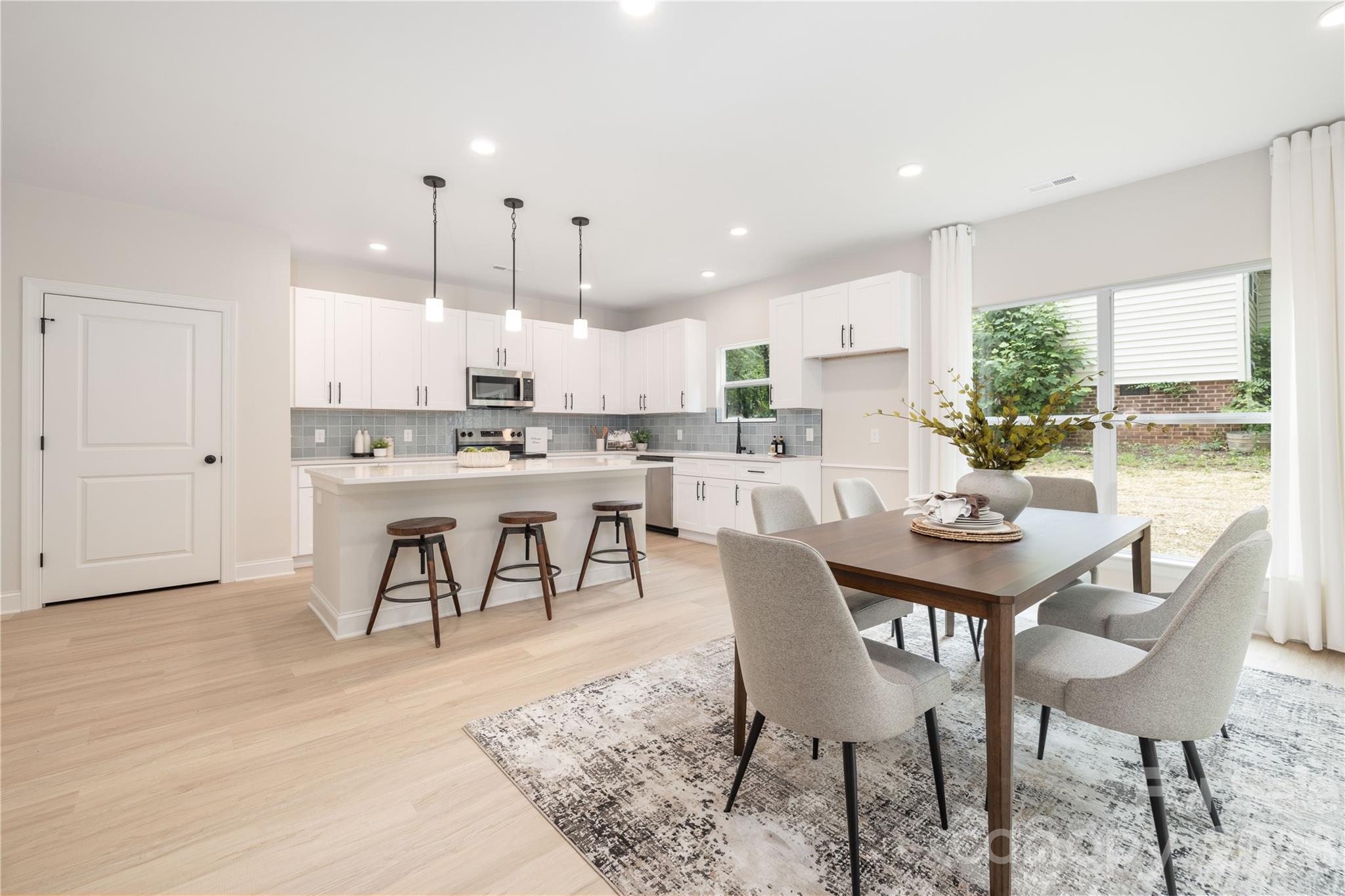 Move in ready new construction in Charlotte, NC with no HOA, located in the highly desirable Grove Park neighborhood. This stunning 4 bedroom single family home includes a true turnkey move in ready package with a 6’ privacy fence, washer, dryer and blinds already included. Builder and lender are offering a 2-1 rate buy down with potential rates in the 4’s, plus this home qualifies for 100% financing and up to $10,000 in closing costs for eligible buyers. Featuring an open floor plan with 9 foot ceilings on both levels, a dedicated home office, 2 car garage, rear patio and luxury finishes throughout, this home checks every box for buyers looking for a brand new home in Charlotte. Upgrades include quartz countertops, white shaker cabinetry with 42” uppers, soft close doors, dovetail drawers, designer tile backsplash, white oak luxury vinyl plank flooring, Pella windows and doors, fiber cement siding, stainless steel appliances and Moen plumbing fixtures. The primary suite offers a beautiful ensuite bath with walk in shower and dual vanity, while the guest baths feature designer tile and modern finishes. Grove Park offers multiple neighborhood lakes, parks and walking trails while being centrally located between Uptown Charlotte, Matthews and Mint Hill. Enjoy quick access to Plaza Midwood, NoDa, shopping, dining and entertainment, with Plaza Midwood and NoDa approximately 15 minutes away and Uptown Charlotte around 25 minutes away. A rare opportunity for buyers searching for a truly move in ready new construction home in Charlotte with modern upgrades, no HOA, builder incentives and flexible financing options.