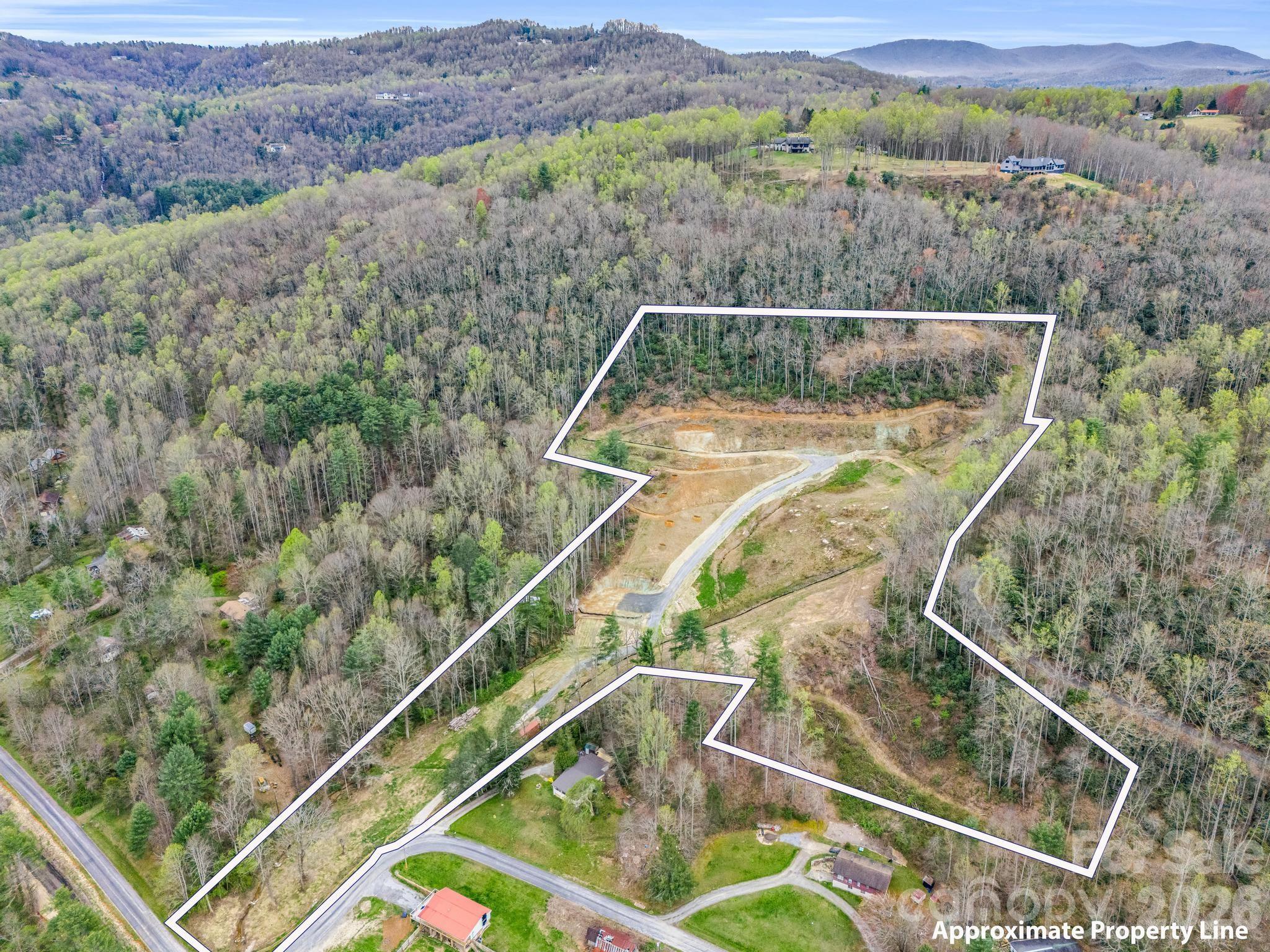 Rare opportunity to own nearly 12 unrestricted acres with direct access to the completed Ecusta Trail, just minutes from downtown Hendersonville. This exceptional property offers at least three premier homesites featuring stunning northern and western mountain views, ideal for a private estate, family compound, equestrian property, or income-producing short-term rental development. There's also an opportunity to rezone to commercial.

Significant site work has already been completed, including a private gravel road to the top of the property, leveled building sites, parking areas, stone bridge, barn site preparation, and installed utilities. Property features include a spring originating on the land, two creeks with beautiful rockwork, well house, electric on site, and two approved 4-bedroom septic permits.

R3 zoning and unrestricted use allow for short-term rentals, farm animals, and multiple living opportunities with no HOA. Enjoy the rare combination of privacy and convenience with direct trail access for walking or biking to restaurants, breweries, and shopping, while downtown Hendersonville is just 4 miles away and Asheville Regional Airport only 20 minutes.

A truly one-of-a-kind legacy property offering privacy, views, water features, and development flexibility in one of Hendersonville’s most desirable locations.