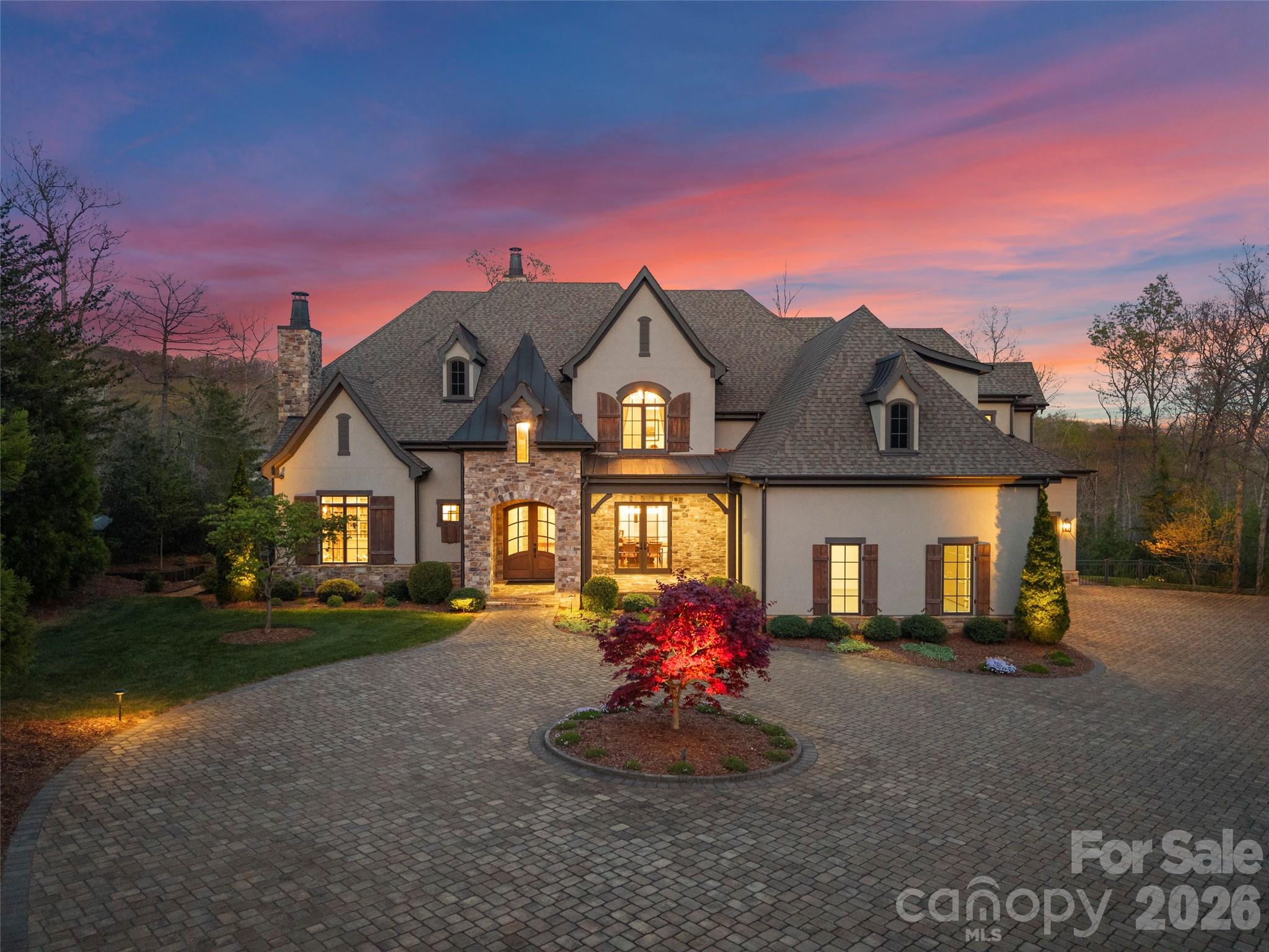 Experience the pinnacle of mountain modern luxury in this sprawling estate nestled within the exclusive gates of The Cliffs at Walnut Cove. Situated in Arden with the Pisgah National Forest as your backdrop, this community offers a rare combination of high-altitude privacy and effortless access to the Blue Ridge Parkway and the vibrant culture of nearby Asheville. With a membership, residents can enjoy a world-class lifestyle centered around an 18,000-square-foot wellness center featuring indoor and outdoor pools, tennis courts, and a luxury spa. The community's crown jewel is the Jack Nicklaus Signature golf course—the only one of its kind in the region—which is complemented by an award-winning clubhouse and "The Tavern," a social hub for fine dining and member events.
Commanding a premier position directly on the fairway, this property offers spectacular views of the manicured greens and rolling mountain vistas. The home itself is a masterpiece of mountain transitional design and precision, boasting 6,640 square feet of heated living area across two meticulously planned levels. The architectural style harmoniously blends rustic natural textures with sleek, modern lines, utilizing a sophisticated palette of stone, timber, and expansive glass to reflect the beauty of the surrounding Blue Ridge landscape.

Guests are greeted by a grand entry that flows seamlessly into an expansive living room anchored by a contemporary fireplace and a stunning wall of glass overlooking the lush landscape. Culinary enthusiasts will marvel at the gourmet kitchen, featuring professional-grade appliances, a massive island, and a dedicated wine room designed for the connoisseur. The main level is designed for effortless living and entertaining, offering a sophisticated formal dining room, a private library with custom built-ins, and a magnificent primary bedroom suite that serves as a sanctuary of comfort.

Outdoor living is elevated to an art form with unenclosed spaces designed to take full advantage of the golf course frontage. Whether you are hosting a summer gathering on the expansive patio, relaxing on the deck, or enjoying a quiet morning on the covered porch, the connection to nature and the serene fairways is ever-present. Retreat to the second floor to find additional bedroom suites, a dedicated club room with a theater for cinematic experiences, and a massive future bonus room that offers endless customization possibilities. Complete with a generous three-car garage and ample integrated storage, this estate is more than just a home; it is a gateway to the ultimate Western North Carolina lifestyle.
