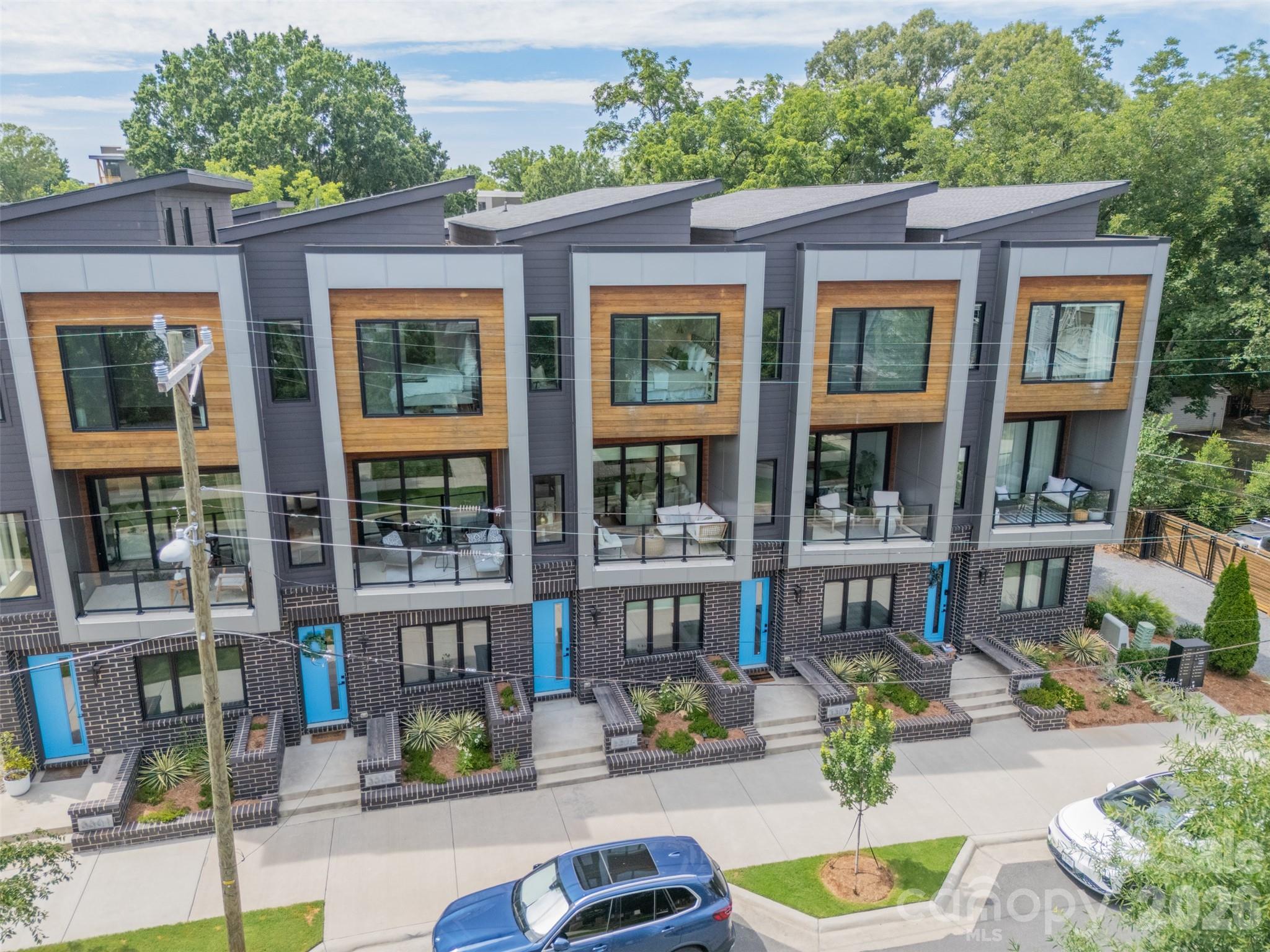 Stunning contemporary townhome offering the perfect blend of urban convenience and peaceful living. This beautifully designed home features 2 bedrooms, 2.5 baths, a dedicated office, soaring ceilings, abundant natural light, white oak hardwood floors on all three levels, and a spacious covered balcony with a sophisticated 3-panel sliding glass door and premium retractable screen.  The entry level includes a private suite with custom shades. On the main level, the designer kitchen has white cabinetry, quartz countertops, and Café GE appliances, opening seamlessly to the spacious living room and covered balcony, perfect for entertaining or relaxing.  Upstairs, the elegant primary retreat features vaulted ceilings, remote-controlled custom shades, two walk-in closets, and a spa-inspired bath with dual vanities and an oversized walk-in shower. The garage offers tall ceilings and generous storage space. Fresh interior paint gives the home a crisp, move-in-ready feel, and the washer, dryer, and refrigerator all convey.  Located just blocks from the heart of NoDa, you'll enjoy easy access to neighborhood favorites, including the new Sprouts Farmers Market, Haberdish, The Local Loaf, Neighborhood Theatre, local breweries, and art galleries. The home is also conveniently located near the 36th Street Light Rail Station, providing quick access to Uptown Charlotte.  Experience the best of city living in Charlotte's most vibrant neighborhood. Welcome Home!