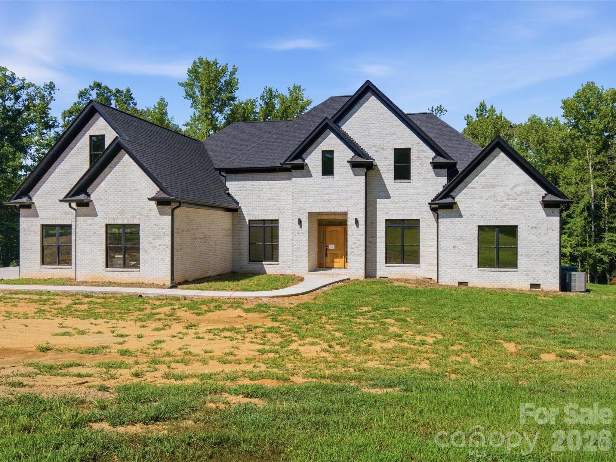 Discover luxury country living on 5 private acres in this stunning newly completed custom home offering over 5,300 heated square feet of thoughtfully designed living space. Originally offered during construction with buyer finish options, this home is now finished and showcases exceptional craftsmanship and high end designer selections throughout. Beautiful stone accents, custom tile work, quartz countertops, oversized luxury plank flooring, craftsman style trim, and soaring 10-foot ceilings create an impressive blend of elegance and comfort.
The spacious main level primary suite features an enormous spa inspired walk in shower, generous walk in closet with room for a center island, and plumbing and electrical already in place for a second laundry area. The gourmet kitchen is designed for entertaining with an oversized island, prep sink, and dedicated coffee bar. A second main level bedroom with private ensuite bath offers an ideal setup for guests or multigenerational living.
The home is currently permitted as a 3 bedroom residence with 4.5 baths and includes two additional unfinished flex spaces already equipped with HVAC, plumbing, and venting, offering potential for expanded bedroom, office, fitness, hobby, or media space. An additional upper level flex area provides even more versatility for a second office, bonus room, or recreation area. Buyers seeking additional bedrooms may explore an engineered septic expansion. Enjoy peaceful views from the covered rear patio accessible from both the great room and primary suite. Additional features include handicap accessible doorways, 400 amp electrical service, two 50 gallon water heaters, approximately 2 acres already cleared, and a 3 car garage with 10 foot ceilings plus a 220 volt outlet in the workshop area.
Landscaping and decorative light fixtures have intentionally been left for the new owner to personalize. The recent price adjustment reflects this opportunity. Oven/microwave cabinet is being corrected to fit this space. 
Appraisal completed and home is priced significantly below appraised value.  Cameras on site.  Please wear shoe covers that are provided. Do not drive past the marked off area/ gravel.  No driving on new concrete.