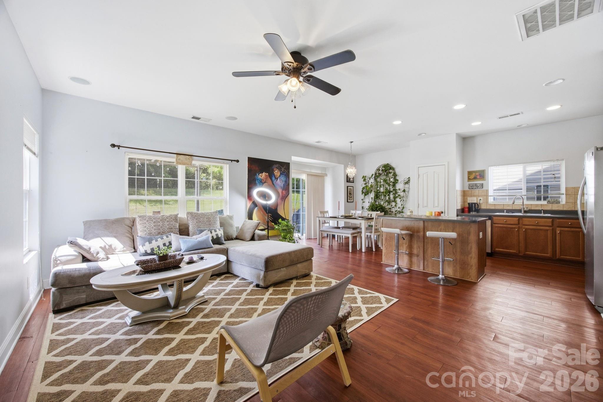 Beautifully designed 3-bedroom, 2.5-bath home with a spacious loft, perfect for a second living area, office, or playroom. The kitchen is the heart of the home, featuring a large center island with bar seating, stainless steel appliances, stylish tile backsplash, and a stunning chandelier that elevates the breakfast area. The open layout flows effortlessly into the family room with surround sound—ideal for entertaining or relaxing. Neutral tones throughout create a warm, move-in-ready feel. Step outside to your private backyard retreat—complete with a deck and pergola, fire pit, extended patio, and stone accent wall—perfect for hosting gatherings or enjoying quiet evenings. Enjoy access to two community pools and a location that truly can’t be beat—just minutes to I-485, I-85, the Charlotte Motor Speedway, shopping, dining, and grocery stores. Conveniently located near the University of North Carolina at Charlotte (UNCC), and with easy access to the Light Rail for a smooth commute to Uptown Charlotte. Comfort, style, and location—this home has it all. Don’t miss your chance!