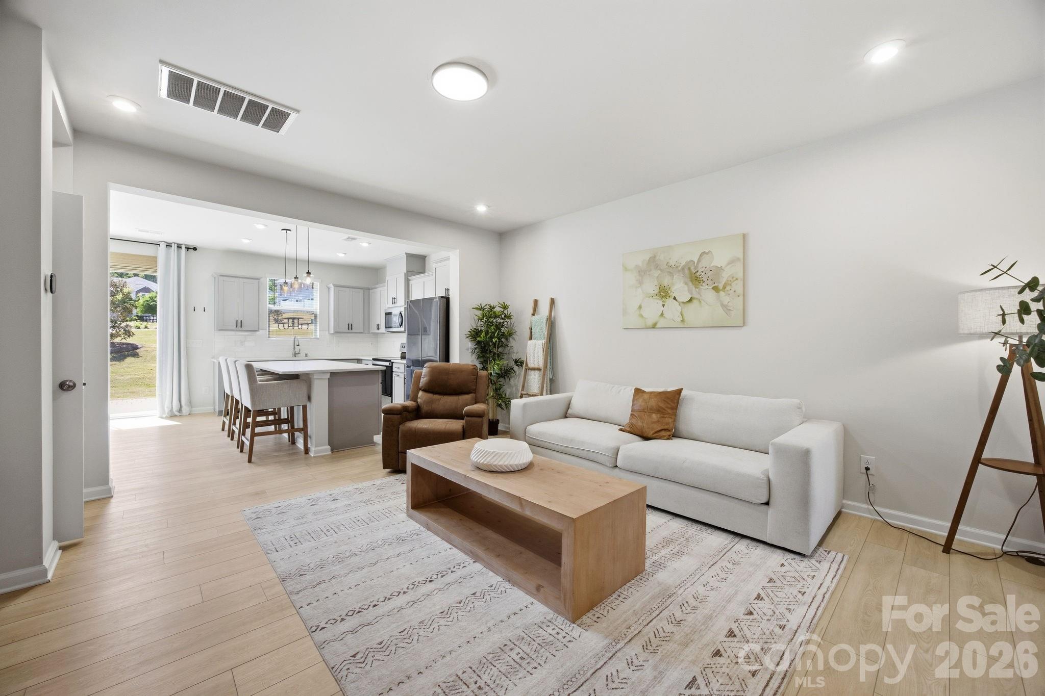 Welcome to this beautifully appointed townhome where comfort, style, and low maintenance living come together effortlessly. The home makes a welcoming first impression from the moment you arrive. Step inside to a thoughtfully designed foyer featuring a built in niche with shelving and an outlet, offering a perfect place for everyday essentials, whether it is a soft glow from a favorite lamp or a convenient spot to keep devices charged and ready as you head out the door. From there, the home opens into a spacious living room that feels both inviting and connected, flowing seamlessly into the kitchen and dining area, an ideal setting for everything from quiet evenings to gathering with friends and family. At the heart of the home, the kitchen is as beautiful as it is functional. Modern gray craftsman style cabinetry, quartz countertops, and a timeless subway tile backsplash set the tone. While the large center island with pendant lighting invites conversation, casual meals, and lingering moments. The sink overlooks the rear yard, offering a peaceful backdrop to your daily routine. Just off the kitchen, the dining area, anchored by a lovely accent wall, opens to the extended patio with privacy screens on each side. Backing to a common area, the outdoor space feels open and expansive, like a natural extension of your home, perfect for morning coffee, evening unwinding, or weekend get togethers. Upstairs, the primary suite offers a true retreat, overlooking the serene rear yard and designed for rest and relaxation. The ensuite bath features a double vanity, upgraded tile flooring, and an expanded tiled shower with a bench seat and transom window that brings in soft, natural light. A spacious walk in closet completes the suite. Two additional bedrooms provide flexibility for guests, work from home needs, or growing households, while the hall bath with double vanity and the conveniently located upstairs laundry room make daily living that much easier. Thoughtful touches like a walk-in linen closet and upgraded open stair railing enhance both function and the light, airy feel throughout. The attached one car garage is a flexible space currently used as a home gym, ready to adapt to your lifestyle. This townhome is ideally located just moments from Lake Wylie, McDowell Nature Preserve, and Rivergate Shopping Center so get ready to enjoy easy access to outdoor recreation, dining, and everyday conveniences. Move right in and start enjoying a carefree lifestyle just in time for summer.