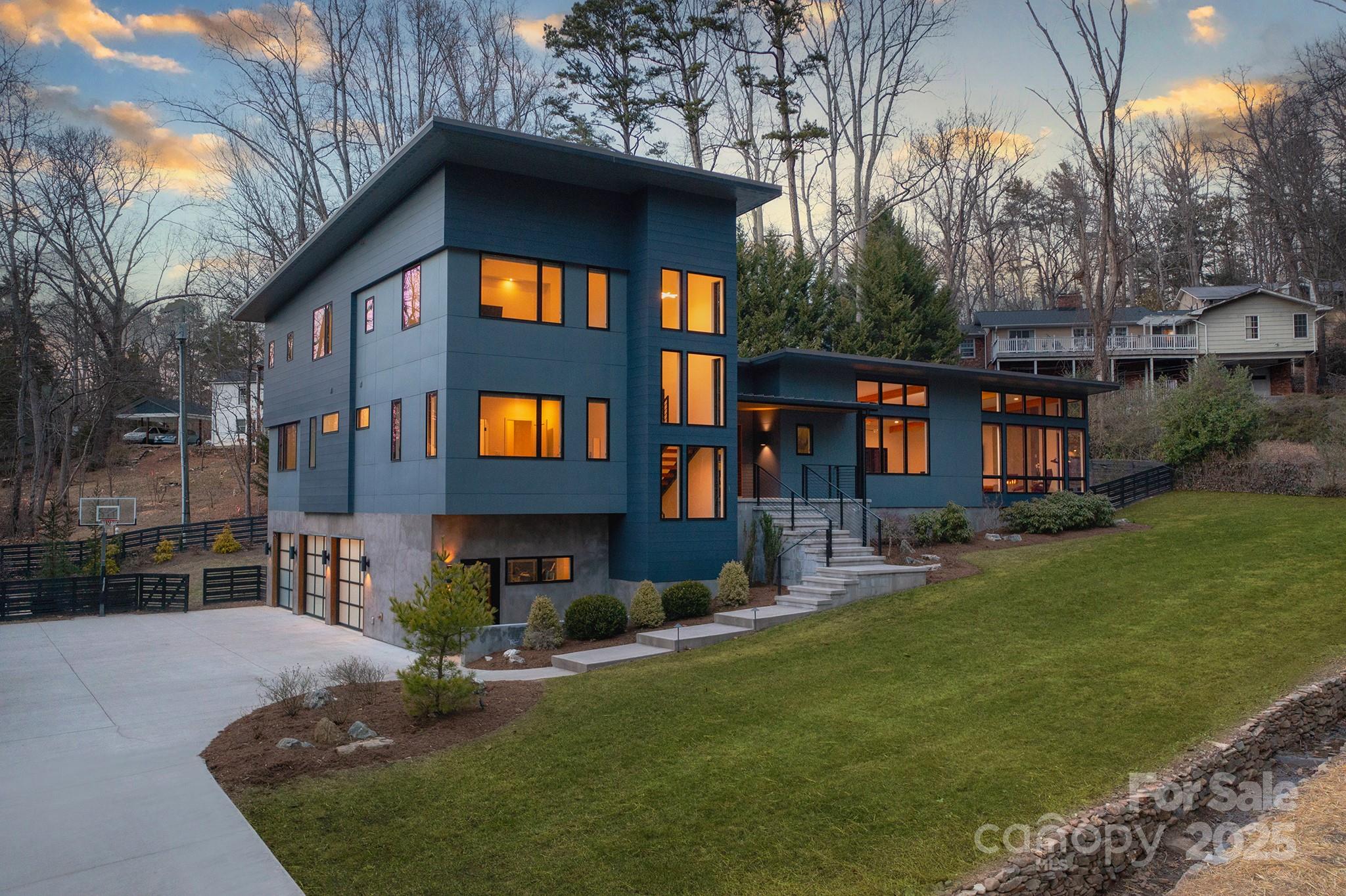 This contemporary masterpiece is nestled into one of North Asheville’s most coveted neighborhoods, near the Grove Park Inn and Spa and its sports complex with indoor and outdoor pools, gym, tennis courts, and 18-hole championship golf course! Custom built in 2019, this 4,700 SF architectural gem encourages serenity. Under the nickel-gap shiplap ceiling, breathe out and take in peaceful views from floor-to-ceiling windows. Relax by the living room’s inline fireplace, or enjoy a soothing soak in the spa-like primary bath. After you’re suitably restored, enjoy hosting movie night in the spacious, lower-level media room — or entertain on the huge back deck with an eight-person jacuzzi. Weather not great? Head inside to a kitchen that can handle it all with Thermador appliances, Ultracraft cabinetry, and a gigantic quartz island. When it’s time to wind down, all four bedrooms are suites with full bathrooms. This home is modern and elegant, yet family friendly … a rare opportunity, indeed!