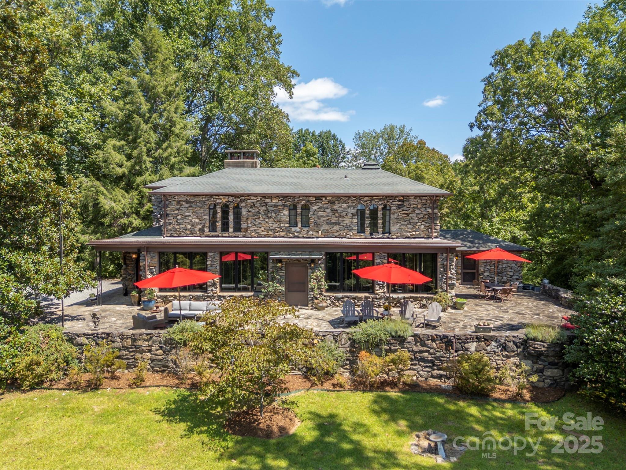 This exceptional estate has been lovingly restored and improved over the years, preserving its historical charm while embracing the conveniences of modern living. Now listed on the National Register of Historic Places, and originally constructed in 1935 for the Costa family, this compound of a main house, a guest house and a pool house, set on 25.94 rolling acres, reflects the beauty and context of its history and the possibility of its future. The Main House blends seamlessly with the landscape and the stone hedges that shape and give it its name. The front door opens into a large and inviting main room with its original oak floors and multiple seating and dining areas - in front of the fireplace featuring a hand-carved mantel from the Tryon Toymakers, on the ‘Florida Tiled’ sunroom with its antique mill stone and southerly views through the massive windows, or outside on the terraces overlooking the pool, rolling hills and the daily sunsets behind the mountains beyond. On the first floor there is also a private office (or perhaps a fourth bedroom) with its full bathroom, a butler’s pantry and bar, a breakfast room with its own wood-burning stove, the gourmet kitchen and exterior doors and windows to the back-covered porch and the front terrace. Upstairs, accessible by elevator or stairs, are the two guest bedrooms with ensuite baths and a large master suite that includes walk-in closets, a gas fireplace, a generous master bath with double sinks and vanity, a walk-in steam shower and an ample soaking tub looking onto mountain views. Walk across the drive to the Guest House and you’ll find a self-contained suite of a bedroom, ensuite bathroom, living room with another full bath and a full kitchen. There is also, via a separate entrance, another bedroom, full bathroom and kitchenette. The Pool House, down the hill from the Main House and sitting comfortably between its heated and covered pool and a stone picnic patio, has its own bedroom with a stone fireplace, pine walls, oak floors, a beamed ceiling and ensuite bathroom. Beneath are two changing and storage rooms with their own baths. Steeped in the history and natural beauty of the foothills of Tryon, North Carolina, the Stone Hedge estate is now available for purchase. Nestled against the escarpment of the Appalachian Mountains with its acres of rolling fields and lawns, beckoning the soul to a simpler time without compromise to modern amenities. Stone Hedge, with its three remarkable stone houses, garages, and a pool, is one of the area’s most desirable and unique landed estates. The rolling fields invite endless possibilities: equestrian pursuits, farming, or simply the joy of open space. The woods provide both privacy and ecological richness, home to deer, foxes, and countless bird species. The streams, trickling across the acreage, bring both life and sound, offering natural water features that enhance the landscape’s beauty and biodiversity If you’re searching for a home base to enjoy everything that Tryon NC has to offer, look no further than the rolling fields and rock walls of Stone Hedge. Less than an hour from Greenville, Spartanburg and Asheville (and their airports) you’ll be well-situated to experience the best of Western North Carolina. This is more than just a property; it's a legacy waiting to be embraced.