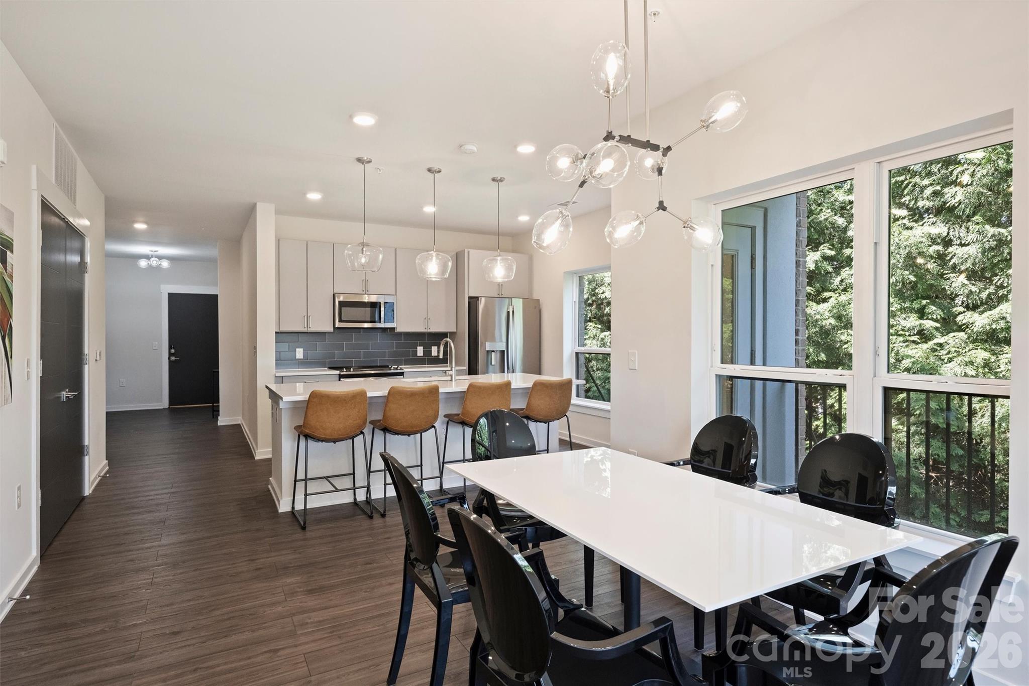 Experience elevated urban living in one of the Arts District's premier boutique condominium communities. Built with modern construction standards, this secure elevator building offers conditioned interior corridors, controlled access, two deeded garage parking spaces and a private interior storage unit—a rare combination with an estimated value of approximately $15,000. These features distinguish it from many of the neighborhood's loft conversions and garden-style communities.

Inside, you'll find contemporary finishes, an open-concept layout, abundant natural light, and thoughtfully designed living spaces that blend style with everyday functionality. Most furnishings are available to convey with an acceptable offer, creating a truly move-in-ready opportunity.

Residents enjoy an exceptional elevated social terrace featuring an outdoor kitchen and grilling area, abundant lounge seating, cozy firepits, and sweeping skyline views—the perfect setting for entertaining, relaxing, or taking in the city atmosphere. The building's boutique setting provides enhanced privacy while maintaining the vibrant, walkable lifestyle that the Arts District (NoDa) is known for.

Just steps from acclaimed restaurants, breweries, coffee shops, galleries, and the light rail, this residence offers the perfect balance of modern convenience and neighborhood character. Whether you're seeking a primary residence, a lock-and-leave urban retreat, or a turnkey second home, this exceptional condo delivers the advantages of newer construction, secure access, valuable parking and storage, outstanding resident amenities, and an unbeatable location in the heart of Charlotte's most eclectic arts district.