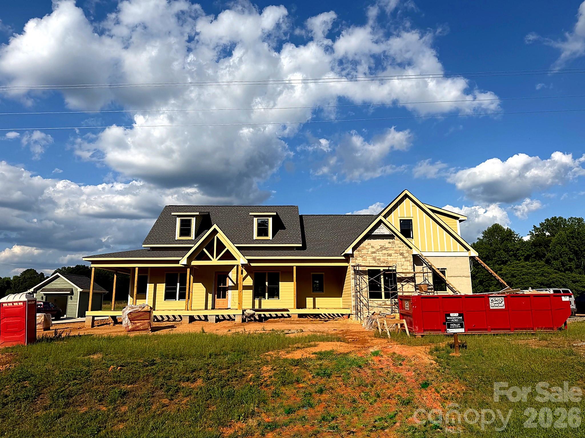 Luxury Custom Spec Farmhouse in Woodstone Communities newest subdivision, Woodstone Acres, with no HOA set to be completed 9/11/2026. The “Holly” is a 1.5-Story ranch with a bonus room upstairs offering approximately 3,107 sq. ft. with 4 bedrooms, formal dining room, huge bonus room upstairs, all designed with upscale finishes and is set on a huge .76-acre lot. The open chef’s kitchen features custom cabinetry, upgraded quartz countertops throughout, gourmet Forno gas range and appliances. This all opens to your living room area that features a gas fireplace, a 12’ sliding patio door leading to your huge 1,000+ sq. ft. covered porch with Trex decking allowing for indoor/outdoor entertainment. The primary suite offers a huge bedroom, spacious walk-in closet with custom built-ins and dresser drawers, and a spa-inspired bath with soaking tub and custom tilework. Additional highlights include a 16-speaker stereo system, beautiful engineered hardwood, tile and carpet flooring, custom wood shelving throughout, abundant storage, and nearly 1,000 sq. ft. of unfinished walkout storage space. Exterior features Hardie siding with beautiful stone for lasting curb appeal and a sealed crawlspace foundation equipped with a dehumidifier. This is a great opportunity to get in early at the beautiful Woodstone Acres.