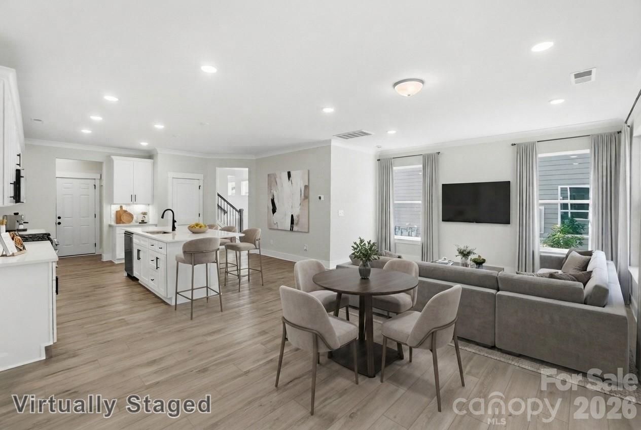 This end-unit townhome has 3 bedrooms, 2.5 baths, and an attached, expanded 1-car garage with a storage area. The garage entry with built-in drop zone leads into the open family room and kitchen. The kitchen features Shaker-style white cabinets, quartz counters, a tile backsplash, and stainless appliances, including a gas range. Beautiful and durable Enhanced Vinyl Plank flooring runs throughout the main level, and all baths feature white quartz counters & cabinets. The primary bedroom, located on the second floor, includes a large walk-in closet. The primary bathroom features a luxury, tiled shower with bench seat and semi-frameless door, two separate vanities, and a linen cabinet. The second floor also has two additional bedrooms, a full bath with tub/shower combo, a spacious loft, and the laundry room. Other extras include a tray ceiling in the foyer, Craftsman-style trim, and stairs with composite treads & metal balusters. Visit today!