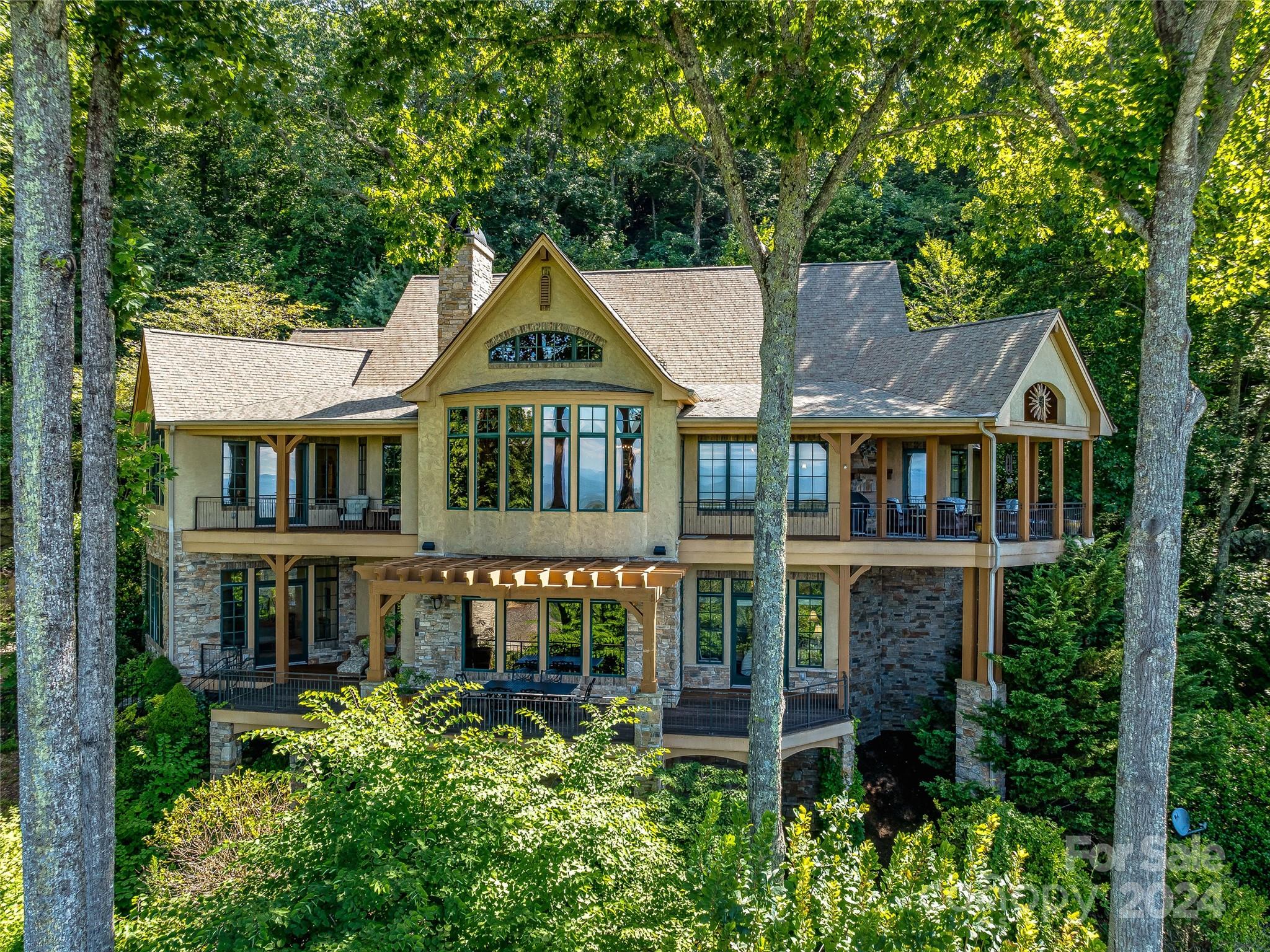 From the moment you walk in this beautiful French Mountain home you experience expansive breathtaking mountain views. As the sunsets in the west the sunset views over the Mountain scenery are unparalleled by any. This beautiful timeless home has superb craftmanship with attention paid to every detail. The Lux finish work is stunning including special wall treatments, stone fireplaces and ceiling details with wood beams. The vaulted ceilings and open concept make the home live large and is perfect for entertaining. The beautiful furnishings set the mood. This stunning home lives well with the master suite, great room, office, dining room and covered porch with fireplace on the main floor. Lower level boasts a TV room with bar and two separate quest suites. A third suite is over the garage. This home encompasses the beautiful Blue Ridge Mountain views from almost every room. Fully Furnished and on a private cul-de-sac with beautiful landscaping just 20 min from Asheville and shopping.
