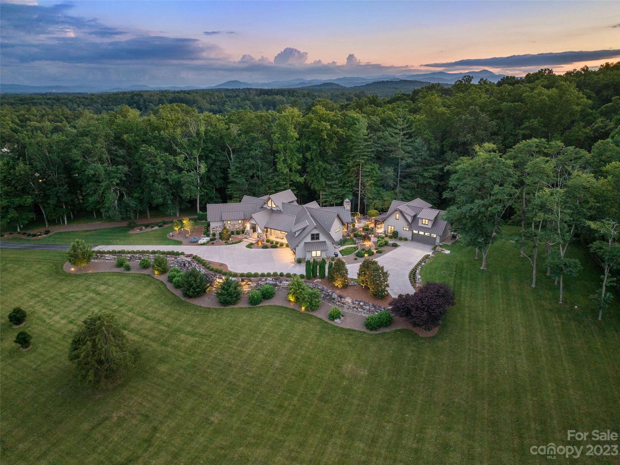 Welcome to an unparalleled oasis nestled within the prestigious Ashbrook Farms community in Cane Creek Valley. Ideally situated on an expansive 11+ acre parcel, this luxurious residence offers refined one-level living with the added bonus of a full guest house. An exceptional opportunity for multi-generational living or hosting guests in style, this private wooded setting offers lush lawns, mature trees, and fabulous outdoor living spaces. The main house has geothermal heated floors, an inviting woodsy screened porch with fireplace, and elegantly designed living spaces. Both houses have attached garages, separate generators, and gorgeous finishes. Enjoy the scenic beauty and rural charm, while still being just minutes away from the vibrant amenities of the Asheville area. From hiking and biking trails to renowned dining and shopping destinations, the best of Western North Carolina is right at your fingertips.