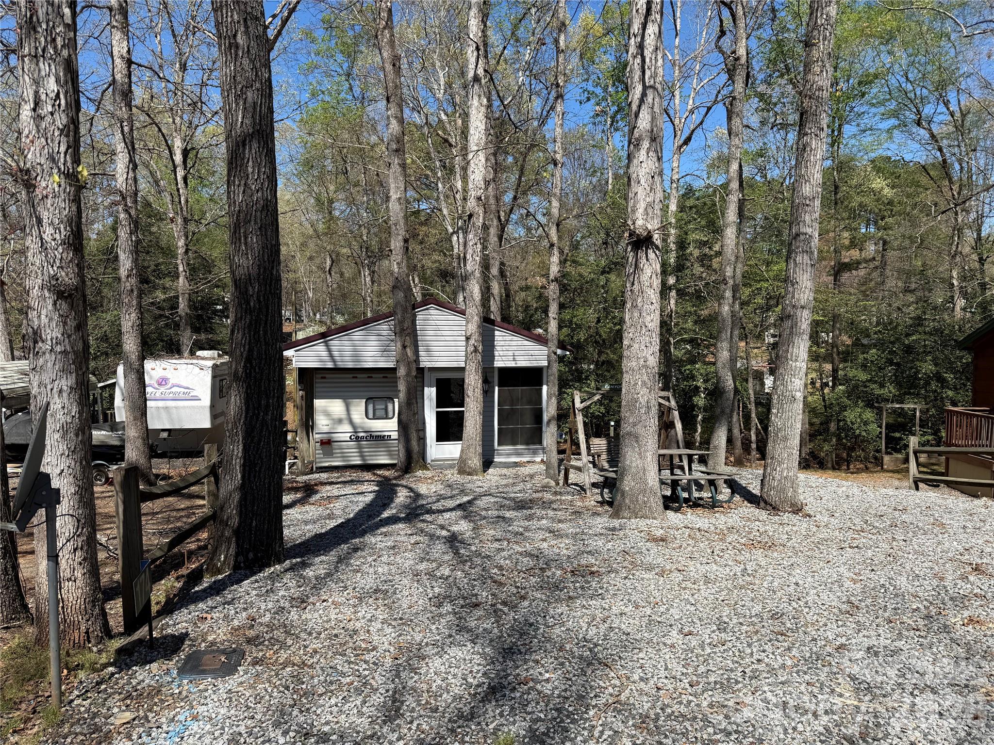 Welcome to 174 Canyon Loop. 2 bedrooms, 2 baths with 2 extra beds for additional sleeping. This unit has turned the camper into sleeping for six. The additional has a new kitchenette and full size bathroom. Easy Breezy windows facing in a great direction to minimize the heat from the sun.  Nice view out the windows and the lot backs up to some common area so no one is behind you. Lot is of the larger size at .10 for plenty of parking. Nice building out back that can accommodate your golf cart. The camper and the addition both have mini splits for your heating and air conditioning needs, approx 3 years old. Full size refrigerator included. 40 gallon elec water heater. What is there is to remain. The kitchen and bath in the camper has been shut down and not in use for many years. Everything worked when they turned the camper into sleeping only. 
The sub floor in the addition has been done and is ready for the flooring of your choice. There is structural damage to 3 of the rafters in the ceiling from a limb falling on the roof. This is right at the front of the unit. Builder stated he can shore it all up for between $2000 to $2500.
The replacement handle to the addition has been ordered and should be in about a week. 
All buyers must be with a realtor to gain entry to the community.