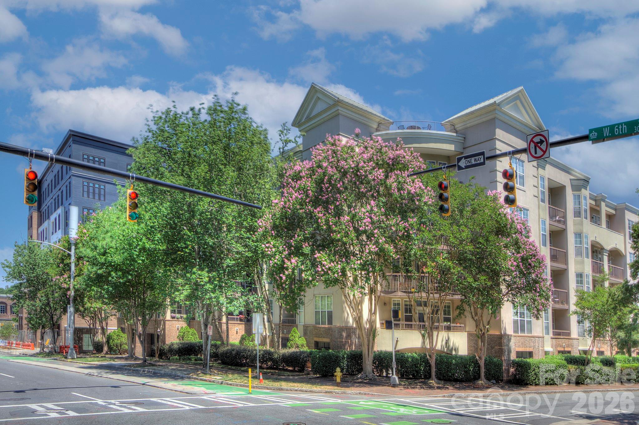 Rare opportunity to own a true 3-bedroom, 2-bath flat in the heart of Uptown Charlotte in Fourth Ward. This open-concept condo offers an ideal combination of space, functionality, and urban convenience with windows on both sides of the home, filling the interior with exceptional natural light throughout the day. The spacious living area features LVP flooring, updated lighting, 9-foot ceilings, ceiling fans, and a rare natural gas fireplace—an uncommon feature in Uptown condo living. Step outside to your private balcony and enjoy city views in one of Charlotte’s most walkable locations.  The kitchen is designed for both everyday living and entertaining with white cabinetry, stainless steel appliances, gas range, microwave, refrigerator, and island with generous counter space overlooking the main living area. The primary suite includes a walk-in closet and en-suite bathroom, while two additional bedrooms provide flexibility for guests, office space, or roommates. Additional features include 2” blinds throughout, concrete and steel construction for added sound insulation and durability, and a gated parking deck with assigned parking plus abundant overflow and guest parking.  Residents also enjoy access to a rooftop terrace with gas grills and panoramic Uptown skyline views. Located directly across from Fourth Ward Park and the Uptown Harris Teeter, this home is just moments from restaurants, sports venues, greenways, entertainment, and everything Uptown Charlotte has to offer. Rare combination of size, layout, parking, gas utilities, and location in one of Uptown’s most desirable residential settings.