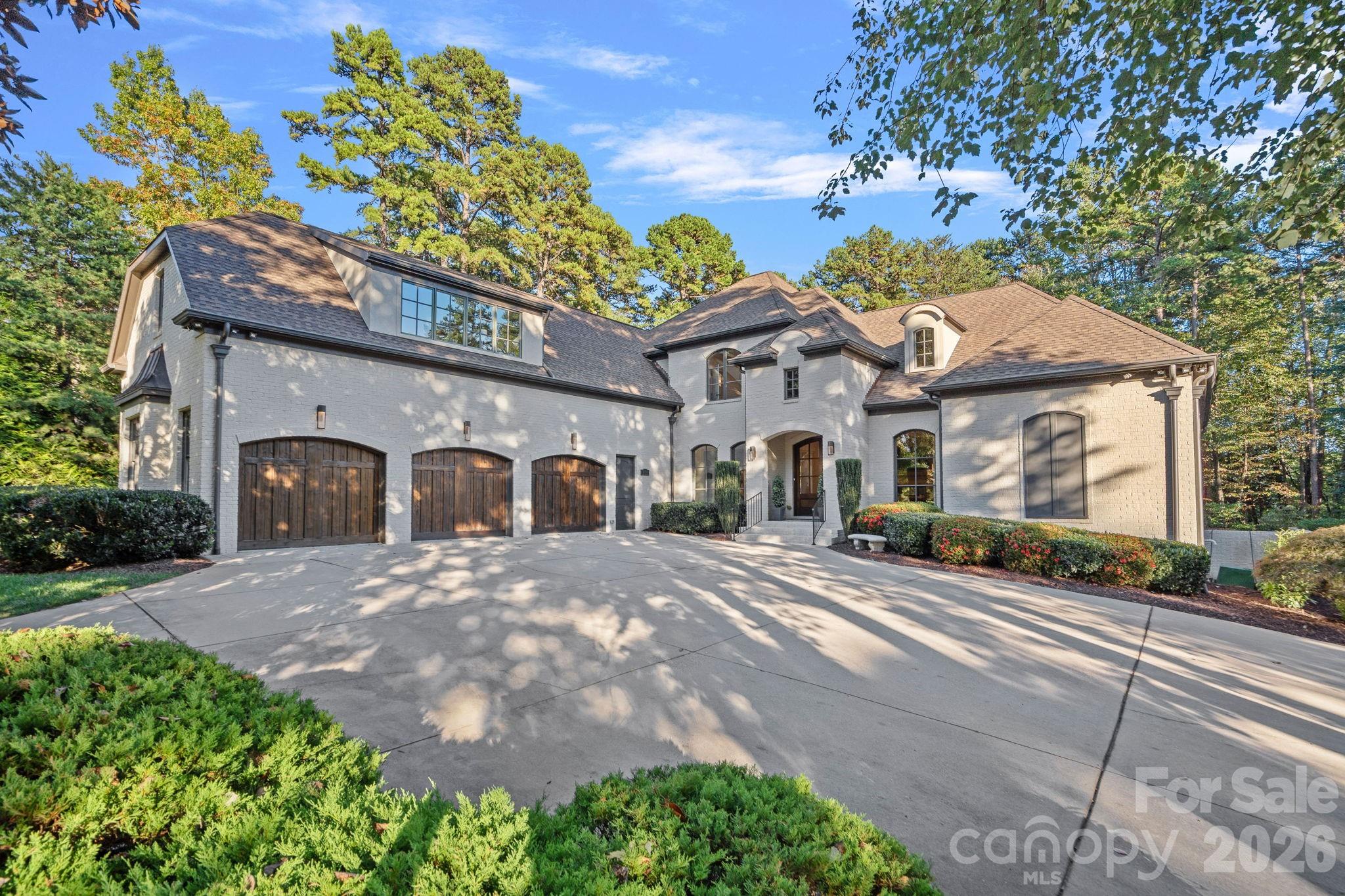 Completely reimagined through a comprehensive interior renovation, this luxury residence reflects an exceptional level of finish and thoughtful design throughout. From the fixtures and lighting to the tile, cabinetry, and architectural details, every space has been carefully updated with no detail overlooked. Set on 1.52 acres overlooking the 8th green of Trump National Golf Club Charlotte, the home blends refined style with exceptional livability. The chef’s kitchen serves as the centerpiece with custom cabinetry, premium appliances, a 12-foot island, two dishwashers, and a scullery featuring pantry storage, coffee bar, and second refrigerator. Just off the kitchen, the breakfast room offers added flexibility and may also serve as a keeping room. A custom bar with lit shelving and a pass-through temperature-controlled wine room adds another layer of thoughtful design.

Designed for both everyday living and entertaining, the main level includes coffered ceilings in the family room, arched windows, elevated lighting, and custom Andersen bifold doors that open to the outdoor living spaces. The main-level primary suite is a private retreat with a renovated bath featuring heated floors and a professionally designed closet with built-in linen storage and washer and dryer. A heated and cooled 3-car garage adds comfort and function.

Upstairs, a spacious flex room was designed for a future suite or private retreat, with plumbing in place for a bath. The upper level also includes a recreation room with built-in bar, second-level office, and secondary laundry room.

Outdoor living is equally well considered with a saltwater pool and spa, built-in grill area, covered patio with retractable screens, and see-through fireplace. The setting offers a high level of privacy along the 8th green, with the cart path positioned on the far side of the green and a subtle winter long-range view of Lake Norman. Completing the lifestyle, the boat slip is within walking distance, and the amenities of Trump National Golf Club are just a short walk away.