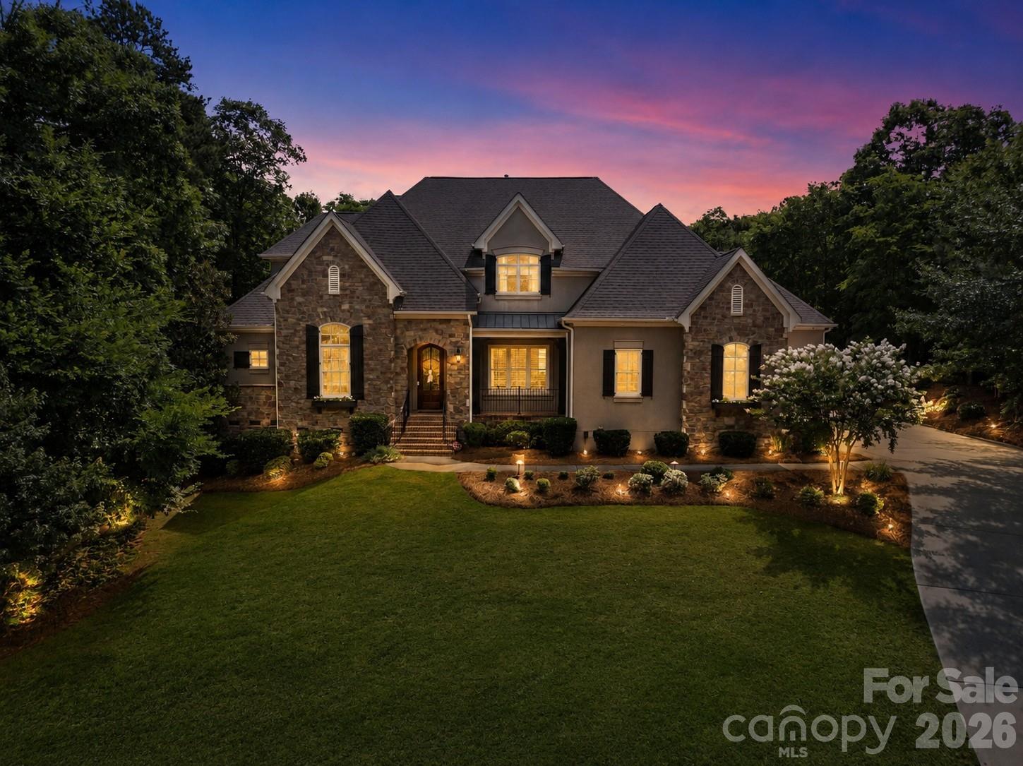 Exceptional craftsmanship, thoughtful updates, and an incredible outdoor retreat come together in this stunning Springfield residence! Set on a private homesite, this custom stone and stucco home offers an elegant open-concept design with soaring ceilings, extensive millwork, and beautifully curated finishes throughout.

The main level is designed for both everyday living and entertaining, featuring a private office with built-in shelving, formal dining room, spacious great room with custom built-ins, and a beautifully updated kitchen with marble countertops, a large granite composite sink, updated cabinetry, and premium appliances. Expansive retractable doors seamlessly connect the interior to the screened porch, where motorized retractable screens create a true year-round living space overlooking the backyard.

The main-level primary suite serves as a private retreat, offering a generous sitting area, spa-inspired bath with heated shower floors, an oversized walk-in closet, and luxurious finishes throughout.

Upstairs, every secondary bedroom enjoys its own private bath, providing comfort and privacy for family and guests. A loft area, spacious bonus room, and abundant storage offer flexibility for a variety of needs, including the potential to create a fifth bedroom.

The outdoor living experience is truly remarkable. Designed for relaxation and entertainment, the backyard features a custom pool and spa surrounded by travertine hardscaping, a putting green, artificial turf, outdoor grilling area, and a safety fence around the pool. Whether hosting gatherings or enjoying a quiet evening, this outdoor oasis delivers resort-style living at home.

Additional highlights include updated lighting, floating shelves in the upper foyer, remote garage door access, garage lifts, a Tesla charging station, and a custom playset.

Located within the highly sought-after Springfield community, residents enjoy an exceptional amenity package including a golf course, membership to Anne Springs Close Greenway, clubhouse, fitness center, outdoor pool, tennis courts, playgrounds, recreation areas, picnic spaces, and miles of sidewalks, creating a lifestyle that is as impressive as the home itself!