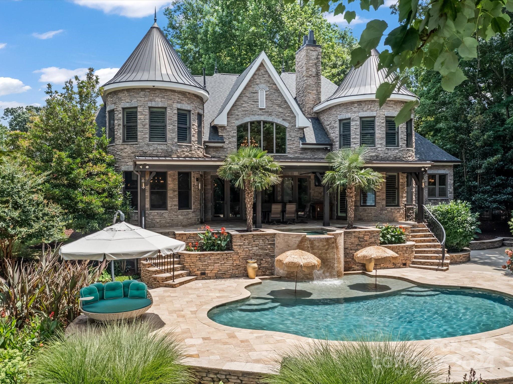 Lakefront lifestyle living awaits at this stunning French Country style home. Designed to capture the lake views and provide a premier outdoor entertainment space, you'll love entertaining on the terrace or around the saltwater pool with a waterfall. Relax on your own private beach and utilize the new beautiful dock with boat lift. Step inside to find an elegant interior highlighted by expansive windows, beautiful hardwoods and chef's kitchen. The open layout seamlessly connects the living spaces, creating an ideal environment for modern living and gatherings. With its spacious bedrooms, including a master suite offering a private retreat with lake views, this home provides comfort and style. There is also an upstairs private suite. Located in a quiet neighborhood with easy access to golf, shopping, and dining, this residence offers a rare opportunity to experience lakeside living in Huntersville. With uptown and the airport less than thirty minutes away, this home truly has it all!