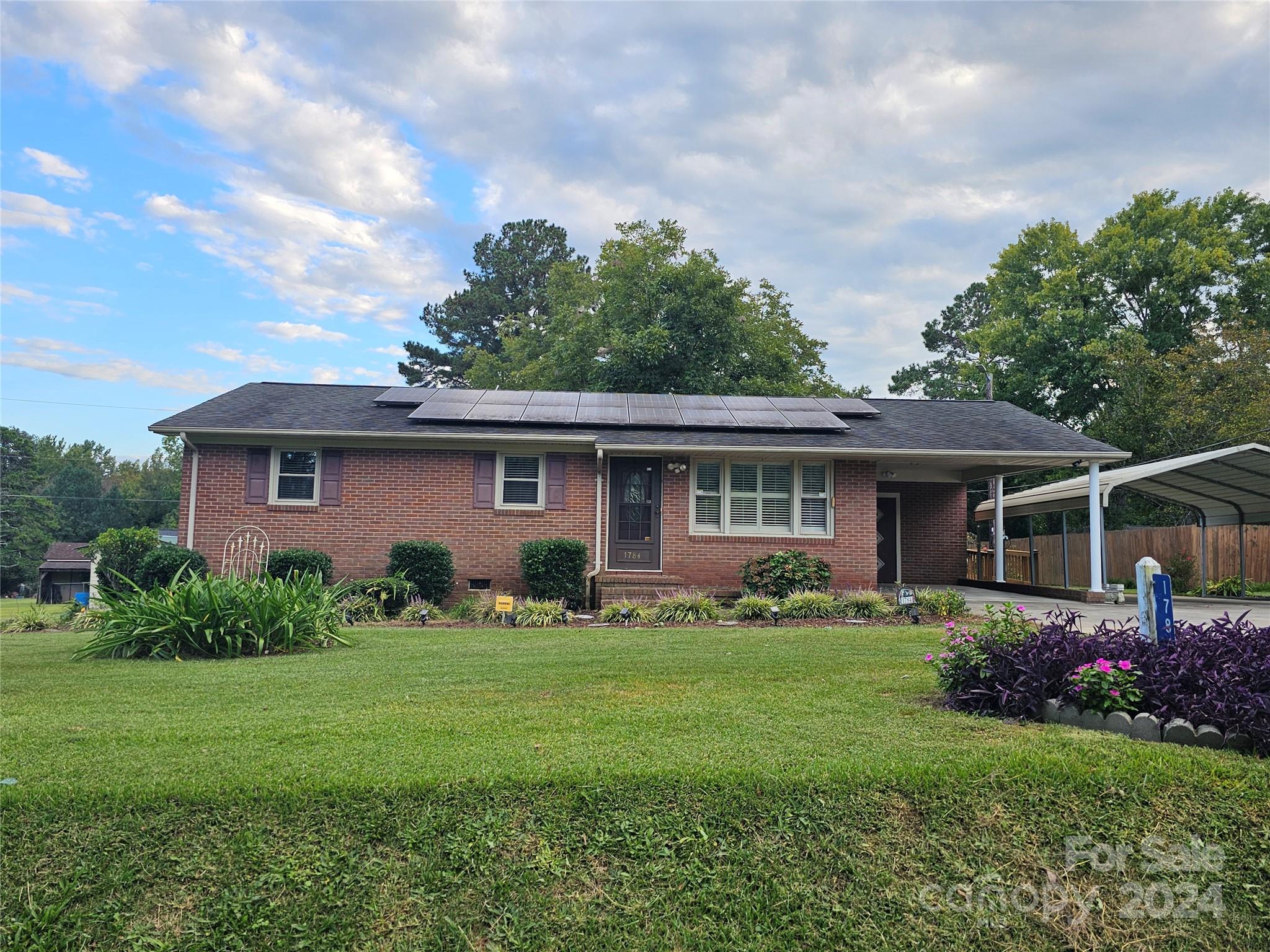 Come and enjoy this wonderful 3 bedroom home.  It features, new windows, updated kitchen, large rear screen porch.  Three outside storage buildings, a single carport attached to the house and a free standing double carport. 
Great mature lawn.  The house has solar panels.  Home is being sold "as is."