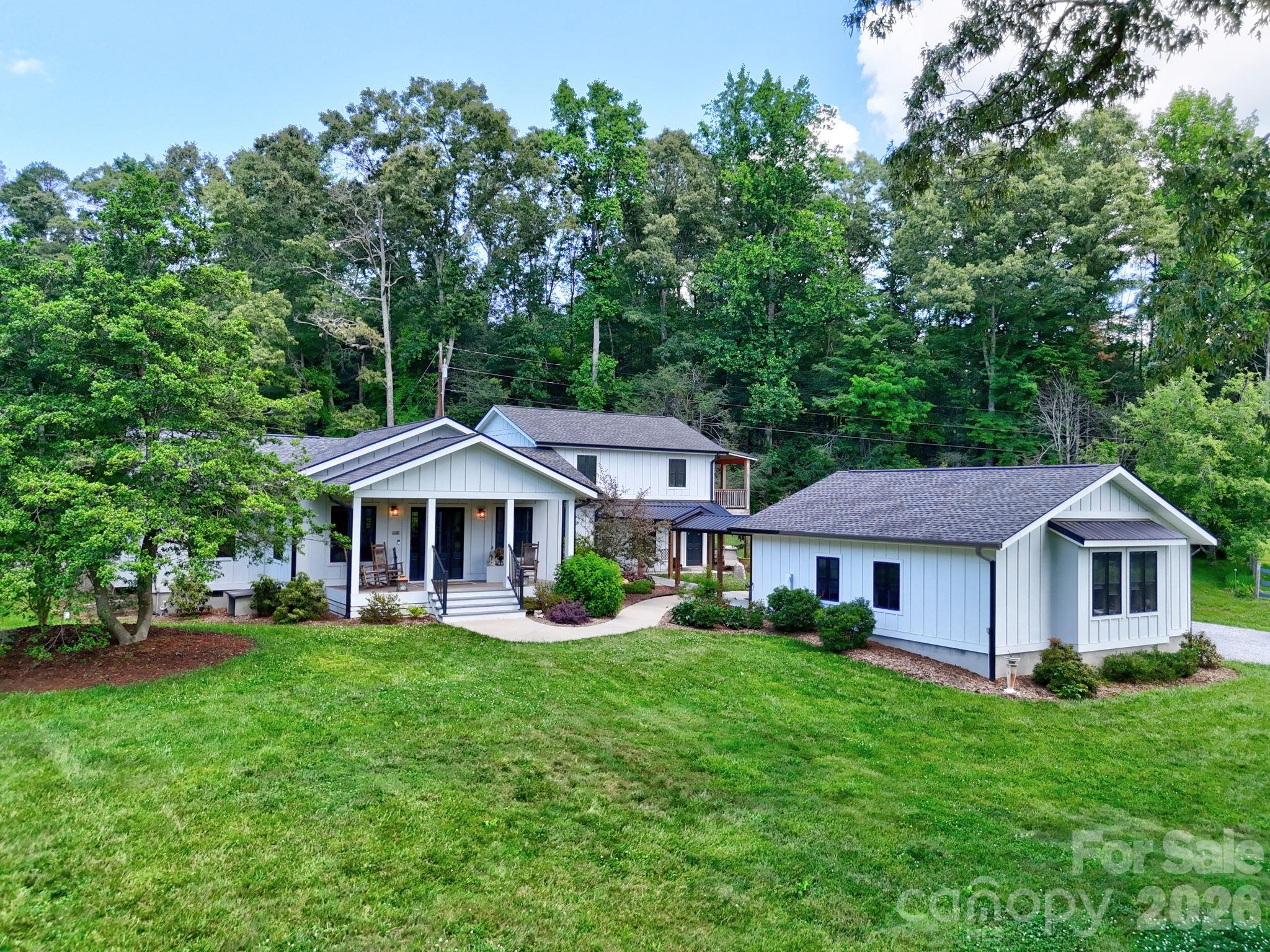 Experience the perfect blend of luxury, privacy, and mountain living in this stunning modern farmhouse, completely rebuilt in 2019 and situated on more than 9 fully fenced acres. Designed as the builder's personal residence, this exceptional 3-bedroom, 2.5-bath home showcases quality craftsmanship and thoughtful details throughout.

Conveniently located just 20 minutes from downtown Hendersonville, 15 minutes from Asheville Regional Airport, and 25 minutes from downtown Asheville, this remarkable property offers the tranquility of country living with easy access to shopping, dining, and entertainment.

The home's open-concept design is highlighted by a spectacular great room with cathedral ceilings, abundant natural light, and breathtaking mountain and pasture views. The expansive kitchen features white granite countertops, stainless steel appliances, and generous workspace, making it ideal for both everyday living and entertaining. The main-level primary suite offers a private retreat with a spa-inspired bath featuring a soaking tub, walk-in shower, and spacious layout.

Enjoy peaceful mornings and stunning sunsets from the covered front porch overlooking rolling pastures and long-range mountain vistas. Upstairs, you'll find two oversized bedrooms, a beautifully appointed full bath, and a covered balcony where the mountain views become even more spectacular.

A breezeway connects the home to a two-car garage and workshop, providing both convenience and functionality. Equestrian enthusiasts and hobby farmers will appreciate the three fenced pastures, horse barn, and large equipment shed. Multiple potential building sites offer additional opportunities to take advantage of the property's exceptional long-range mountain views.

With no restrictions, incredible privacy, and endless possibilities, this is a rare opportunity to own a turnkey mountain estate.