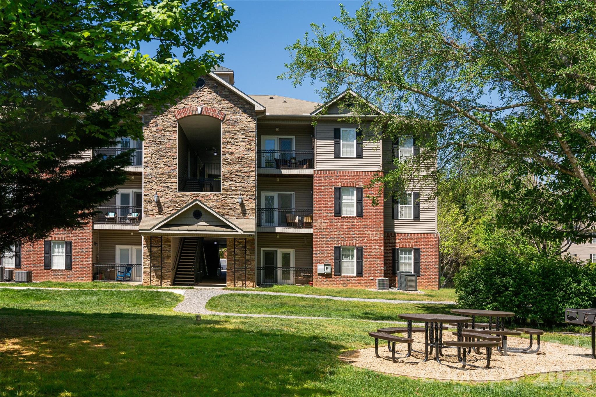 Discover maintenance-free living in this top-floor 2-bedroom, 2-bathroom condo located in the sought-after Grove at Appledoorn community. Offering a light and bright open floor plan featuring 9' ceilings that seamlessly blends the kitchen with the living and dining areas. Step outside onto your private, covered balcony to enjoy exceptional mountain views. Situated in a prime location, this home is just minutes away from the historic charm of Biltmore Village and the vibrant dining and entertainment scene of Downtown Asheville. This quiet 3rd-floor unit is one of the most well-located units in the community, providing a balcony overlooking the park with no neighbors above you. The interior includes a spacious primary bedroom suite with a private bath and walk-in closet, a second bedroom or office and  separate bathroom, a large laundry closet, and a private storage area. Gently lived in as a second residence, this home has been well-maintained and is move-in ready. The Grove at Appledoorn is a walkable, pet-friendly community featuring picnic tables and grills in the green space where neighbors often gather. Monthly HOA fees include city water and sewer, trash and recycling, and exterior and grounds maintenance. Please note that only owner-occupied units are permitted in this community; no rentals are allowed.