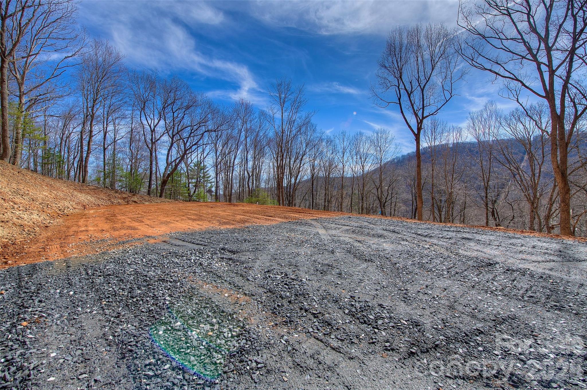 Your brand-new home place has been carved out on a mountain in Spruce Pine, NC at the top of Poplar Trail— part of the Holly Dale Lands, adjacent to Little Switzerland and just off the Blue Ridge Parkway in the greater Dale Road Community— an area that is exploding with the nicest of homes for working professionals and retires alike.  THIS IS THE PLACE TO BE! 

This 1.74 Acre view lot is 100% READY for your build!  You have a brand new 3 bedroom septic in place, community water ready for hook-up, electric to the property, well built and graveled drive, along with well maintained community roads, hydro seeding in place, cleared mountain views, and NO HOA!

Your drive in to the property brings you across the “Rusty Spur Farm” which is a working mountain equestrian/cattle farm at the bottom of the mountain and features a beautiful pastoral scene of horses and the occasional mischievous calf that gets through the fence on occasion.  It is drives with scenes like this that are more and more rare these days as society outside these mountains progresses.  
IF YOU APPRECIATE magnificent mountain scenery and the companionship of people with broad interests; If you would like to live or vacation clean and pure— where you can enjoy, but avoid most of the annoyances of urban, suburban or commercialized resort areas, perhaps you should join the interesting folks who have chosen to build their permanent and/or vacation homes and legacy in this area of our ancient mountains.
Your neighbors in this community are people of achievement in their respective professions and businesses— of good taste, with a wide variety of creative interests. Here, at Holy Dale Lands Inc., you can build a beautiful year-round residence, or a vacation retreat at less cost per square foot than in most other sections of the country. 
You do have deed and value protections, in the way of some light community covenants, but there is NO HOA!  Also, it’s important to acknowledge: THE DEGREE OF FREEDOM IS HIGH, & PROPERTY TAXES ARE LOW!
The emphasis here is on enjoyment of one of the most beautiful mountain regions in the entire world; on simple forms of outdoor recreation; on clean mountain living; on companionship with interesting people, and small town schools and sports— as well as complete privacy when desired.
The Holly Dale Lands Community is approximately mid-way between New York and Florida, and is easily one days drive from 60% of the entire US population— New York, Philadelphia, Washington D.C., New England, Florida and the Mid-west.
No matter the road you take, to or from here, it’s always the “scenic route!” This ridge top awaits your legacy— your family’s crest or shingle is ready to be erected here in this small town enclave.
You are just 5 minutes away from downtown Spruce Pine, The Grassy Creek Golf and Country Club, and the Blue Ridge Regional Hospital; 5 minutes to the Blue Ridge Parkway and 10 minutes to the Linville Falls Winery— perfect for wine, music and weekend relaxation; 15 minutes aways from the famous Penland School of Crafts; You will be 15 minutes to downtown Burnsville, or 30 minutes to fine dining, ski resorts and other entertainment at Banner Elk, Beach Mountain, and Sugar Mountain, as well as Mountain Glen Golf Course in Newland; 20 minutes to Lake James, Marion, and I-40; 50 minutes to Asheville, NC; 60 minutes to Johnson City, TN, and the Tri-Cities Airport. This community is two hours from Charlotte, NC.