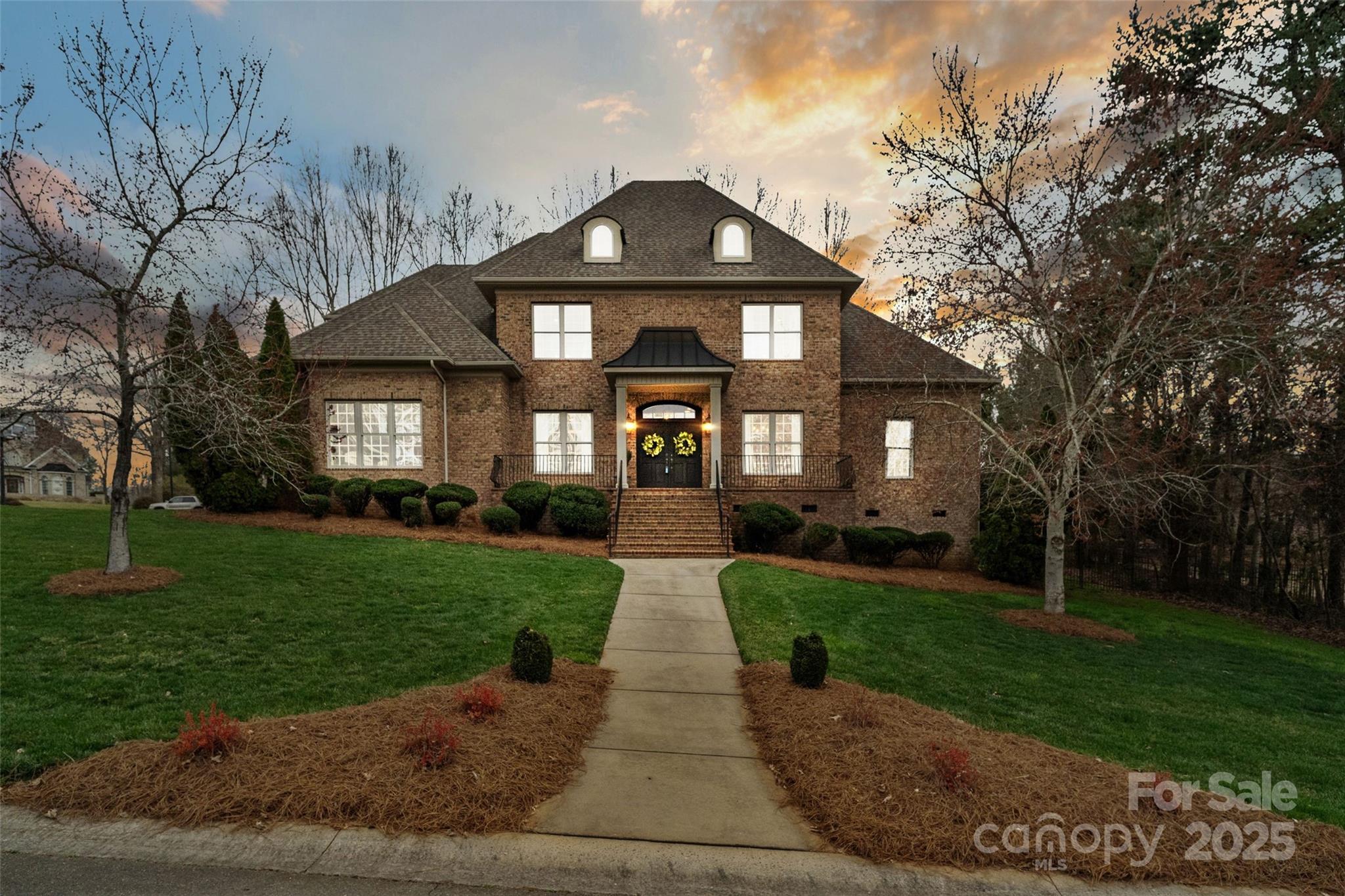 This custom-built house is a delightful blend of modern and traditional design elements which gives it a unique and stylist aesthetic. Located in one of Rock Hill's most prestigious neighborhoods, this 4600 square feet estate offers ample living space on the main floor for living and entertaining. When you walk through the double front doors, you will notice the pristine hardwood floors, exquisite moulding, custom built-ins, and dark painted doors throughout.  While the primary suite is conveniently located on the main floor, there are 4 additional guest rooms (each with a private bath) and a bonus room upstairs. The house offers enormous closets and walk-in attic space throughout -an organized homeowners dream. Step out the back door onto your private patio and grilling area or enjoy the lovely fire-pit on brisk evenings. During the summer enjoy a stroll by the beautiful lakes or the neighborhood pool and tennis courts.