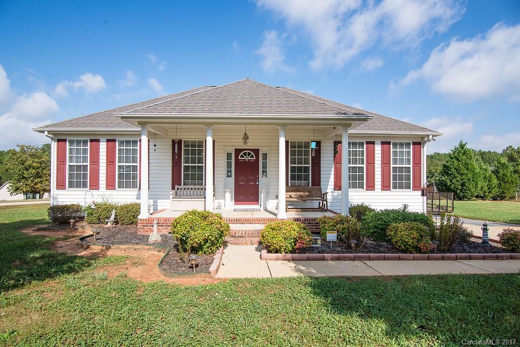 Charming front porch, open floor plan with vaulted ceiling in great room, gas log fireplace, new flooring, fresh paint, corner lot with large deck and yard, storage shed/outbuilding.