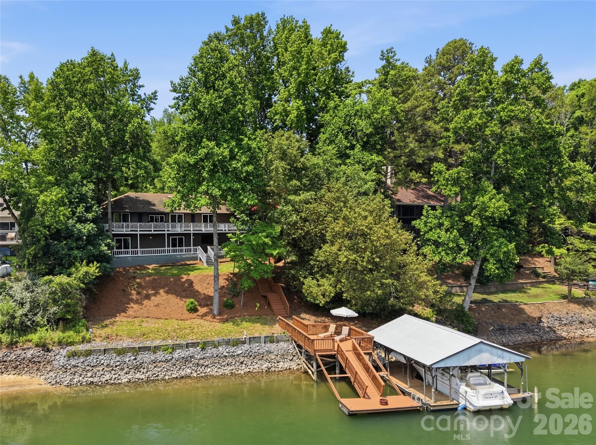 Live the ultimate lakefront lifestyle in this stunning, updated Tega Cay masterpiece! Offering glorious lake views this 4-bedroom, 4-bathroom home is perfectly designed for both everyday living or entertaining friends and family. The spacious great room features a cozy fireplace and flows seamlessly into a dining area framed by breathtaking, picturesque water views. Channel your inner chef in the updated kitchen, boasting granite countertops, stainless steel appliances, abundant cabinetry, and a charming breakfast area. One car garage with storage rounds out the main floor.  The lower level serves as a perfect retreat, featuring three comfortably sized bedrooms, 3 full baths, a generous family room with fireplace, and a large laundry room complete with barn door. No detail was overlooked in the recent renovations, which include new flooring, designer lighting, modern fixtures, and fresh paint throughout. Outdoor living is truly unmatched. Entertain and take in the views on the massive main-level composite deck or lower level patio. The property features a covered dock with a boat lift,  swim dock, and seating area ready for your lake adventures. Enjoy Tega Cay’s resort-style amenities including golf, pickle ball, tennis, swimming, ball fields, and trail system.  Award-winning Fort Mill schools and convenient to shopping and dining!