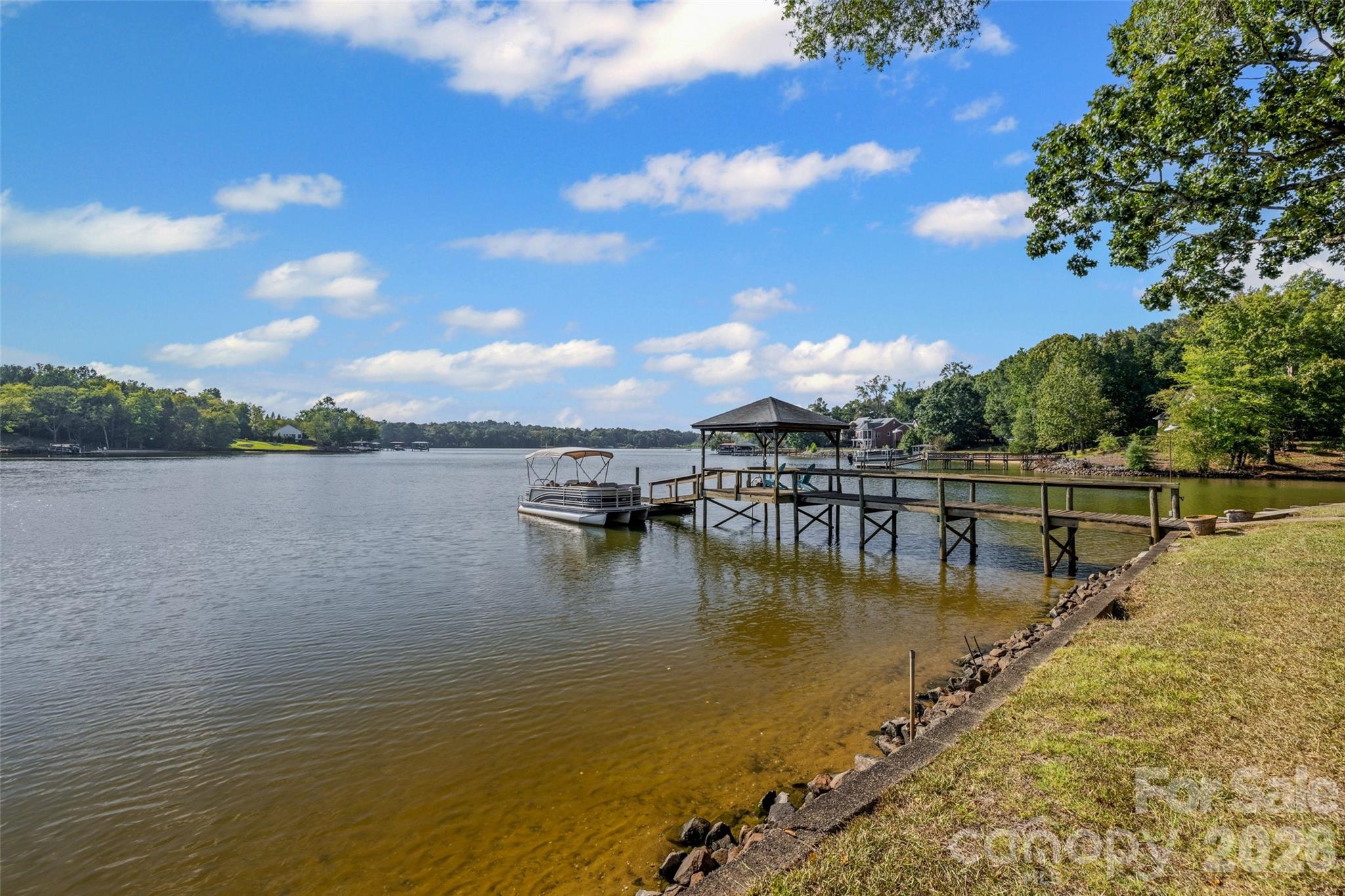 Welcome to an incredible and rare find on Lake Wylie, offering over 300 feet of shoreline and 2 parcels totaling an expansive 5.45 acres with waterfront acreage. Located in the desirable Clover School District, this home and land combines privacy, space and direct access to the lake in one of the area’s most sought-after locations. The home provides a comfortable space with a spacious kitchen, inviting living room and sunroom, new carpet and a shaded lot with spectacular sunset views over Little Allison Creek. Use the existing home as a weekend retreat, a micro-farm, or live in it while you build 1 or more custom dream home. With three detached storage buildings, a carport and irrigation already in place, the property is ready to serve a variety of lifestyle needs. The grandfathered-in pier, dock, ramp and steps create immediate access for fishing, swimming and boating. You'll love the big-water views just steps from the home, while still enjoying nearby cove access. With frontage on both Bonita and Price Place, you can imagine yourself hosting reunions, weekend get-togethers or quiet evenings by the water. This Lake Wylie retreat was made for memories. Hard-to-find waterfront acreage like this rarely becomes available on Lake Wylie - don’t miss the chance to bring your vision to life in this incredible setting.