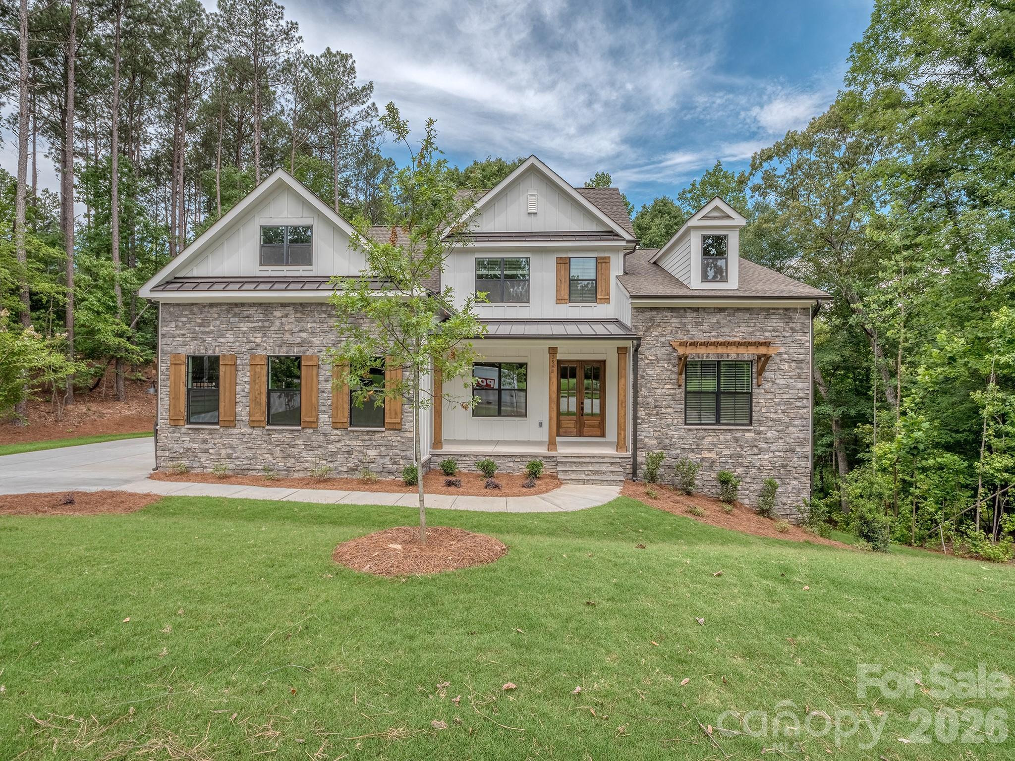 Beautiful new construction in the lake front community, Handsmill on Lake Wylie. This 5-bedroom, 4.2 bath home features .61ac overlooking beautiful hardwoods and a Lake Wylie creek. The 1st Fl has a spectacular open kitchen, great room with fireplace, drop zone leading to the laundry rm and 3-car garage, spacious covered deck with fireplace, office/flex space and a primary bedroom with large bath and custom closet. The 2nd Fl features a bedroom with an ensuite bath and 2 bedrooms connected by a jack and jill bath, a large bonus room and plenty of storage.  The basement is designed for multi-generational living with a full kitchen, dining, media/workout rm, great room, and a second primary bedroom with large closet and bath.  This home also includes structured wiring for networking, speakers and security.  Handsmill is one of Lake Wylie's premier custom communities, featuring a quiet atmosphere, a community pool with clubhouse, walking trails, boat storage and slips for lease.  All of that just minutes from top rated Clover schools, restaurants, and shopping. The home will be complete and ready to close in June 2026.