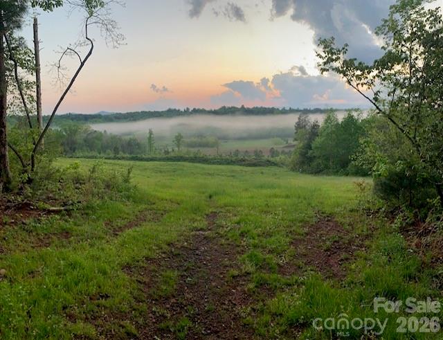 This exceptional 31± acre tract offers a hard-to-find combination of scenic beauty, usable land, and recreational opportunities. Accessed from Tallent Road via a well maintained entrance road, the property welcomes you with a mix of open fields, timber, water, and long-range mountain views.
A potential homesite overlooks the pond and enjoys impressive mountain views, including Dobson Knob, Mount Mitchell, Bald Knob, and South Mountains. This site has been confirmed for a septic drain field and well but no permit obtained by the seller.  This is a great starting point for a future home or mountain retreat.
The land includes several open and tillable fields, with approximately 5 acres enclosed by solar-powered fencing and three access gates. Near the homesite, a stocked pond measuring 15+- feet deep creates both a beautiful setting and a place to enjoy fishing. A nearby block storage building offers convenient space for equipment and supplies.
The property also features an established orchard with pear, apple, plum, and fig trees. A bridged creek provides easy access to another open field, while an extensive trail system winds throughout the property, making it ideal for horseback riding, ATVs, hiking, or simply exploring your own land.
A healthy mix of pine and hardwood timber provides wildlife habitat and natural character across the tract. Whether you're looking for a homesite, mini-farm, recreational property, or a place to enjoy the outdoors with family and friends, this property offers plenty of possibilities.
Conveniently located near Lake James, Lake Rhodhiss, Morganton, and I-40, you'll enjoy the privacy of a rural setting while remaining close to area amenities and outdoor recreation.