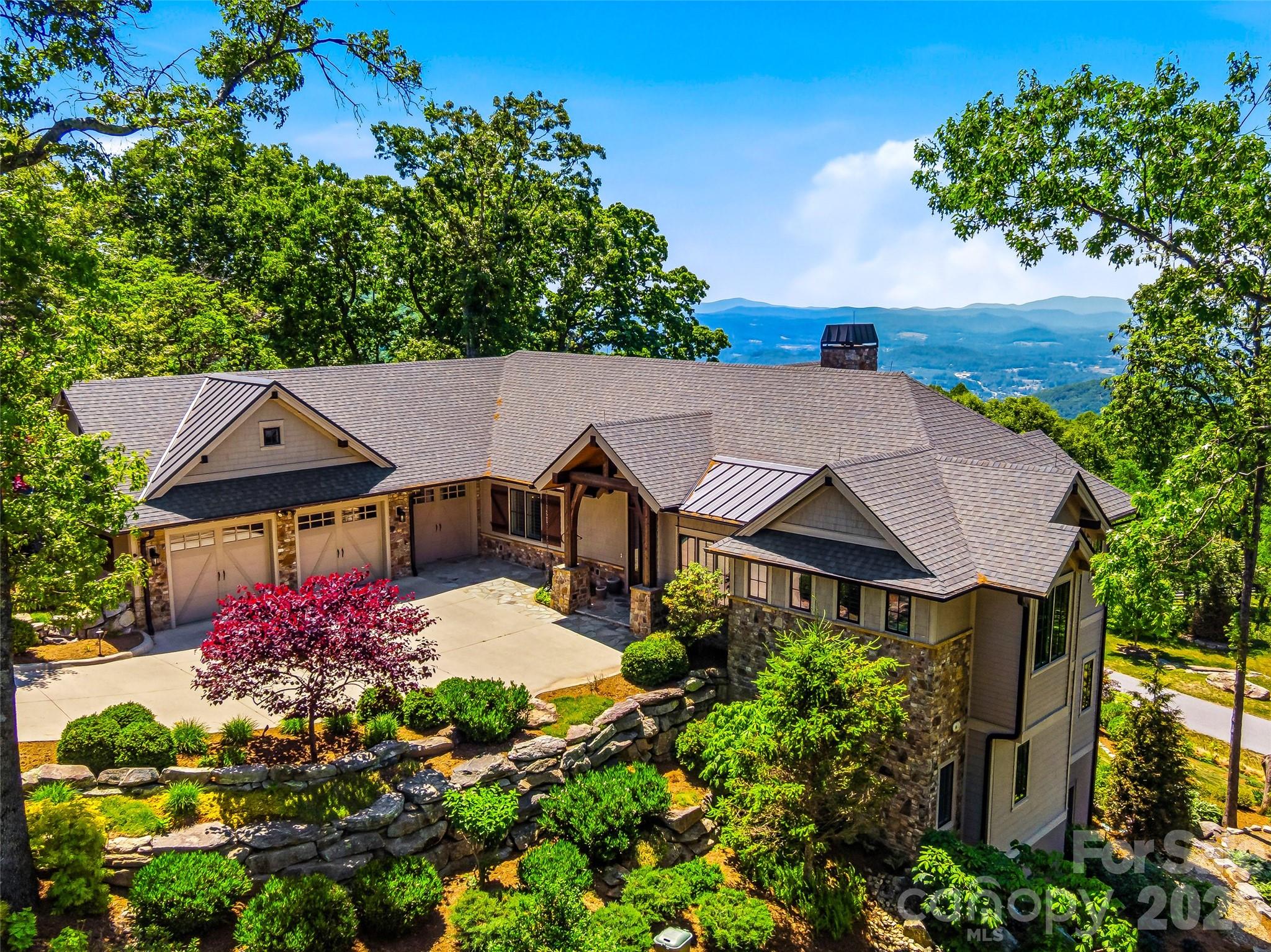 Step into a world where stunning pastoral beauty and long-range mountain views meet architectural elegance. Private and perfectly positioned for southern exposure, this custom, sun-splashed retreat showcases breathtaking 30-mile vistas year round. Designed for effortless main-level living, the open layout features a spacious great room with a gas fireplace, bespoke kitchen, spa-inspired primary suite, dedicated office, and laundry. The screened in porch allows soft summer breezes to waft throughout the upper level. Stacked closets stand ready for a future elevator, ensuring easy multi-level accessibility. The terrace level offers two sizable bedrooms, a guest kitchenette, and versatile finished flex spaces. Equipped with a geothermal system, generator, and smart technology, this residence marries luxury with peak efficiency. Complete with a heated garage and a dedicated golf cart bay, it's a quick cruise to the enclave's Mountain Clubhouse for tennis, pickleball, and fitness.