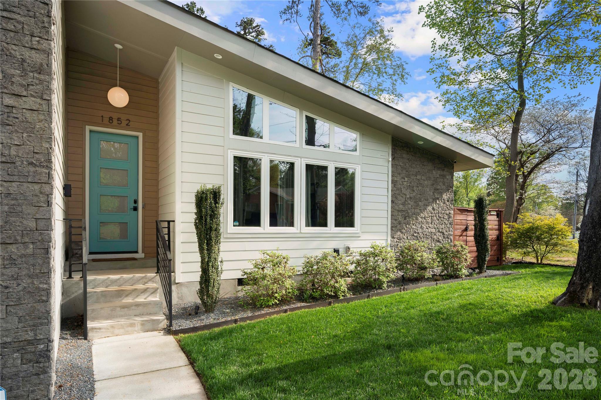 Charlotte’s Shannon Park welcomes you to this stunning 2,252 sq ft mid-century modern home where style meets comfort. Built in 2020, this thoughtfully designed residence is one of only five exclusive homes in the Usonia on Lakedell community. 
From the moment you arrive, you’ll notice the striking curb appeal with clean horizontal siding, warm stone accents, and a welcoming front porch. Inside, the open-concept layout features soaring ceilings, expansive windows, and abundant natural light throughout the main living spaces. 
The modern kitchen is built for both everyday living and entertaining, showcasing custom cabinetry, quartz countertops, tile backsplash, gas range, and a large island that flows seamlessly into the spacious living and dining areas. 
The primary suite provides a spacious retreat with a private ensuite, while two additional bedrooms offer flexibility for guests, family, or a home office. 
A spacious two-car garage adds convenience and extra storage.
Set on nearly half an acre, the property offers a large, fenced backyard with beautiful landscaping, exterior lighting, a rear deck, and patio—plus a smart irrigation system to keep the lawn lush year-round.
Ideally located just 2.5 miles east of Plaza Midwood off The Plaza, this home delivers modern design, functional living, and a prime Charlotte location all in one.
