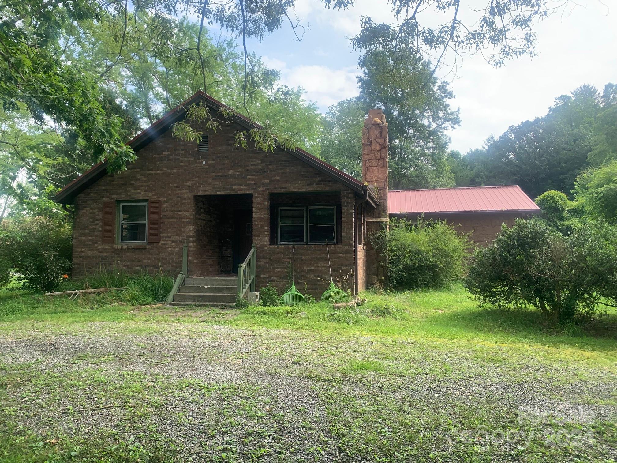 Subject property sold "as is, where is, with all faults". Fixer-upper with lots of potential. This property will not finance and will need to be a cash purchase. Over 1 acre with frontage on Brevard Road, right across from The Plaza at Horse Shoe. Detached garage/workshop and two other outbuildings. Drawings of on-site sewer pump system attached. There is no functioning heat or cooling. Square footage shown only for reference. Zoned CC-Community Commercial.