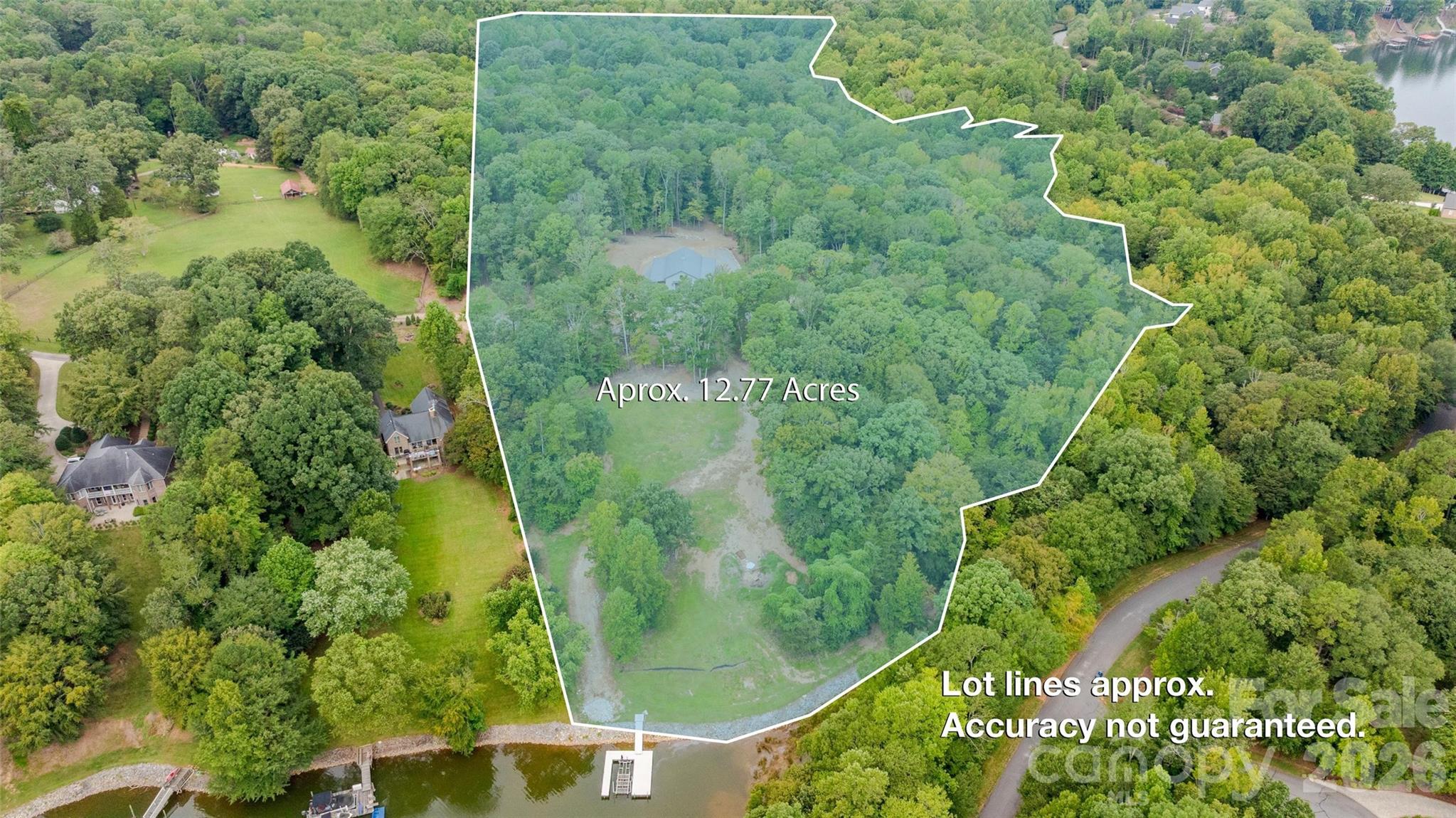 Some Lake Norman properties offer waterfront. Others offer acreage. Few offer both while providing the infrastructure and flexibility to begin enjoying the property immediately. Encompassing approximately 12.77 private acres across two adjoining parcels, this exceptional offering presents a rare opportunity to create a custom waterfront estate without starting from scratch.

Positioned behind a gated entrance at the end of Whispering Winds Drive, the property combines approximately 9.26 acres of improved land with an adjoining 3.51-acre waterfront homesite, creating one of the most unique estate opportunities available on Lake Norman. Gently rolling, predominantly wooded terrain, established trails, a year-round creek, abundant wildlife, and approximately 213 feet of riprapped Lake Norman shoreline that transitions into a continuously flowing creek forming part of the property's boundary, with long water views and immediate access to the main channel, create an exceptional setting for a legacy property. An adjoining subdivision common area provides an additional natural buffer, enhancing the property's privacy and preserving the natural surroundings.

The waterfront parcel has already been thoughtfully prepared for its next chapter with a cleared homesite and an active, transferable four-bedroom septic improvement permit, providing an outstanding starting point for a future custom primary waterfront residence. Whether your vision is a private estate, weekend retreat, or multigenerational property, the setting offers the space, privacy, and flexibility to bring it to life.

Unlike traditional vacant land offerings, this estate includes substantial existing improvements on the adjoining parcel that dramatically reduce the time between closing and enjoying the property. Completed in 2023, the newly constructed accessory residence provides approximately 700 square feet of heated living space with one bedroom, one full bath, and an open-concept kitchen, dining, and living area. The residence is served by its own private well and septic system, allowing comfortable accommodations while the future primary residence is designed and constructed.

An approximately 1,800-square-foot insulated garage and workshop further distinguishes the property, featuring approximately 14-foot ceilings, two 12-foot overhead doors, polyurea epoxy flooring, Galvalume interior wall and ceiling finishes, custom cabinetry, utility sink, ice maker, propane ceiling heater, air compressor plumbing, overhead storage, and exceptional workspace. Additional improvements include covered lean-to storage, a storage building, concrete wash pad, and a 500-gallon propane tank.

A private dock and boat lift (currently without electrical service) provide immediate access to Lake Norman, allowing buyers to enjoy the waterfront from the day they take ownership. With no HOA, no CCRs, exceptional privacy, existing improvements, and one of the rarest combinations of acreage and waterfront remaining on Lake Norman, this is far more than a vacant homesite, it is an opportunity to immediately enjoy an extraordinary property while creating a custom waterfront estate designed for generations to come.