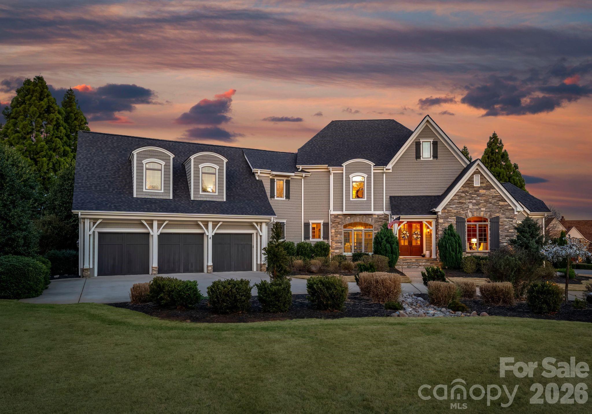 Set along the 14th hole of Trump National Golf Club Charlotte, this exceptional residence captures sweeping golf course vistas paired with tranquil water views, offering a setting that is picturesque. From the moment of arrival, the home’s stately presence is undeniable, elevated by the expansive zoysia turf yard and thoughtful southern landscape. A grand two-story foyer introduces the thoughtfully designed interior, where classic elegance meets modern comfort. A richly appointed wood-paneled study with custom beams provides a refined workspace, while the formal dining room is accented in a sophisticated Tiffany blue creating an inviting space for entertaining. The main living area is warm and welcoming, seamlessly flowing into an expansive screened porch designed for year-round enjoyment. At the heart of the home, the light-filled chef’s kitchen is both beautiful and functional, featuring an oversized center island, marble countertops, and seamless connection to the sunlit breakfast room. The main-level owner’s suite serves as a private retreat, showcasing serene views and a spa-inspired bath complete with a freestanding soaking tub and heated marble floors. Outdoors, the home truly shines. A resort-style backyard oasis features a zero-entry pool with a cascading rock waterfall, an expansive flagstone patio, and a striking wood-burning fireplace—perfect for both intimate evenings and lively gatherings. This home also has a brand new roof (2026!) as well as a tankless hot water heater. A deeded boat slip (Pier O, Slip 11), just a short walk away, provides convenient access to Lake Norman, completing the ultimate lake and golf lifestyle. This is a rare opportunity to experience elevated living in one of the area’s most coveted communities.