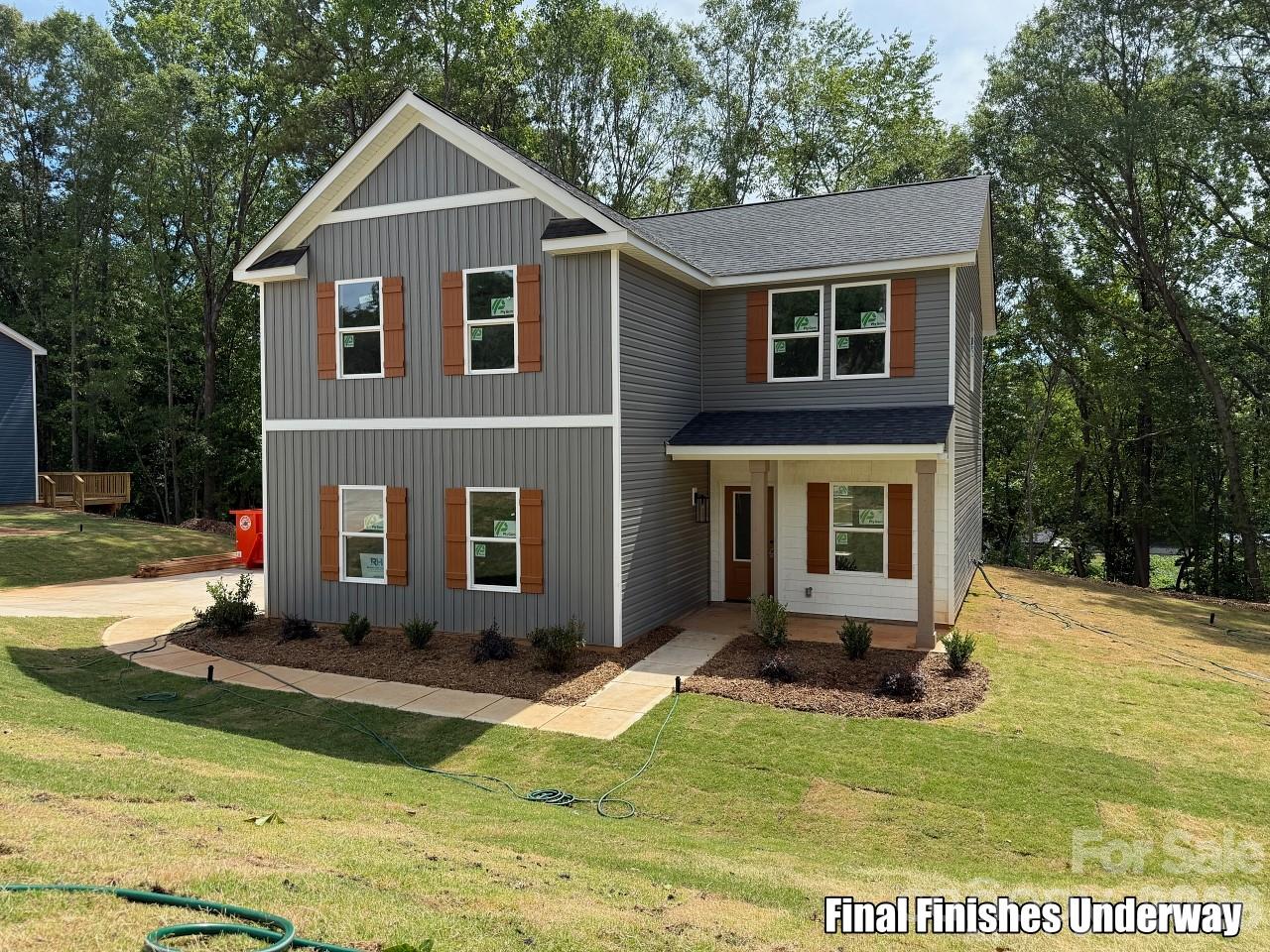 This beautifully crafted 4-bedroom home blends timeless character with modern comfort. Its striking gray board-and-batten exterior, crisp white windows, and welcoming front elevation create outstanding curb appeal. Inside, you'll find an open-concept floor plan featuring luxury vinyl plank flooring, a designer kitchen with contemporary finishes, and a cozy fireplace that serves as the heart of the living space. A dedicated home office provides the perfect setting for working from home or pursuing creative projects, while dual-zone HVAC keeps the home comfortable in every season.

Step outside onto one of the home's most unique features—a spacious elevated deck nestled among mature trees, creating a peaceful, mountain-like retreat that's perfect for morning coffee, entertaining friends, or unwinding after a long day.

Located in the heart of historic Dallas, you'll enjoy the convenience of being just minutes from downtown shops and restaurants, including Front Porch & Provisions and Dallas Tavern & Taphouse, while still having quick access to Gastonia, Charlotte, and US-321 for an easy commute. This home offers the perfect balance of small-town charm, modern design, and a private, nature-inspired setting