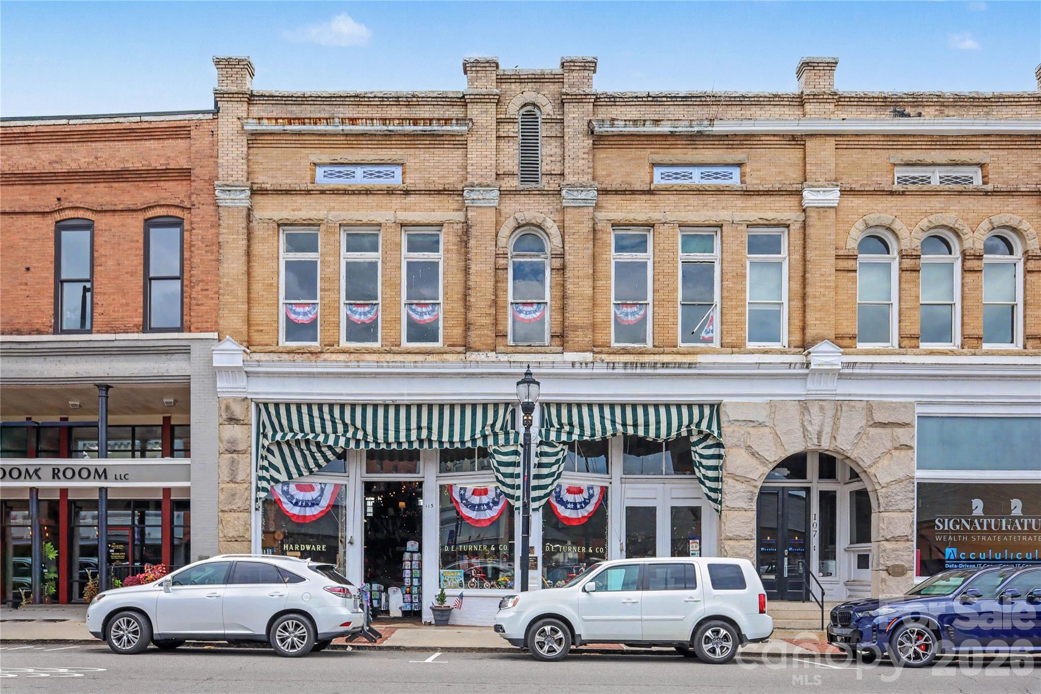 Own a true piece of North Carolina history with the iconic downtown Mooresville commercial building occupied by D.E. Turner Hardware, one of Mooresville's most recognizable commercial properties. Constructed circa 1899, this extraordinary property retains much of its original architectural character and historical significance. This offering comprises a 2-story in-line commercial building and a single-story attached warehouse. The N. Main Street building has 2,632 SF of heated area with soaring 17-foot ceilings, a mezzanine, an entire second floor, and a full basement with 7' ceilings. All 4 levels are serviced by one of the state’s oldest freight elevators. To the rear of the main building is a 3,608 SF single-story warehouse with an interior dock, two loading doors and 11' ceiling height; interior access is through the storefront and exterior access along E. Center Avenue. The D. E. Turner Hardware Store building is widely recognized as one of the oldest continuously operating properties in Mooresville and remains a cornerstone of the vibrant downtown Mooresville Historic District. Historic details include soaring ceilings, hardwood floors, original millwork and vintage fixtures,2 creating an authentic atmosphere that cannot be replicated. The distinguished rusticated granite and brick façade provides timeless curb appeal and an unforgettable presence. Located in the heart of Downtown Mooresville, the property benefits from outstanding pedestrian traffic and is surrounded by popular restaurants, boutiques, breweries, professional offices, apartment buildings, and year-round community events. This is a rare opportunity to acquire an irreplaceable landmark in one of the greater Charlotte-metro and Lake Norman region's most desirable downtown districts. Properties of this caliber seldom become available. Own a building where history, architecture, and investment potential come together in one remarkable location.