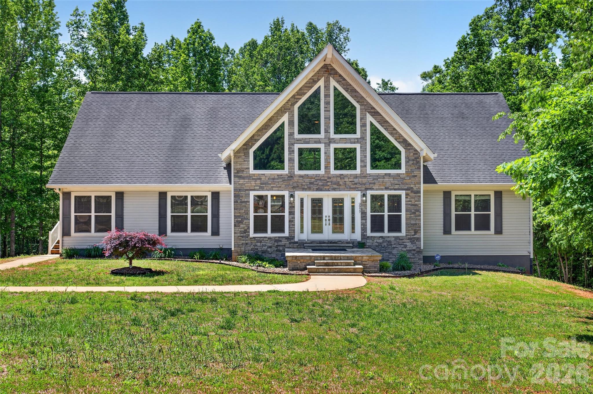 Tucked away on nearly 3 private acres, this one-of-a-kind property offers the feeling of a mountain retreat. Surrounded by nature and complete privacy at the end of a cul-de-sac, this 3 Bedroom, Loft + Bonus Room home delivers the perfect blend of peaceful living and everyday convenience. Inside this STUNNING entrance, gleaming hardwood floors, vaulted ceilings, and an inviting open layout create a warm and welcoming atmosphere and functioning main-level living. The kitchen features upscale custom cabinetry, granite countertops, stainless steel appliances and excellent flow for entertaining and daily living. Outdoor living shines with a spacious screened porch and expansive 40' x 12' deck overlooking the serene wooded yard, ideal for relaxing and enjoying the sights and sounds of nature year-round. Raised planting beds, some fruit trees and even a treehouse are a homesteading dream. The basement and garage are definitely a stand-out feature offering over 2200 sft, plus a full bathroom with walk-in shower, flexibility for work shops, recreation, home gym, hobbies, work-from-home business owners and auto enthusiasts or simply open those garage doors for open air entertaining. Garage floors are plumbed with hydronic radiant floor tubing system. Just outside, designated hot and cold spigots with dedicated wiring ready for your Hot Tub and a whole-home generator.  Additional highlights include dedicated RV parking with power hookup just off the concrete driveway.  A setting that truly feels like a private mountain getaway without sacrificing access to shopping, dining, and major highways because Sherrills Ford, Claremont, Newton, Conover, Statesville and Hickory are all near. NO HOA, NO City taxes make this Move-In Ready Home a rare find!