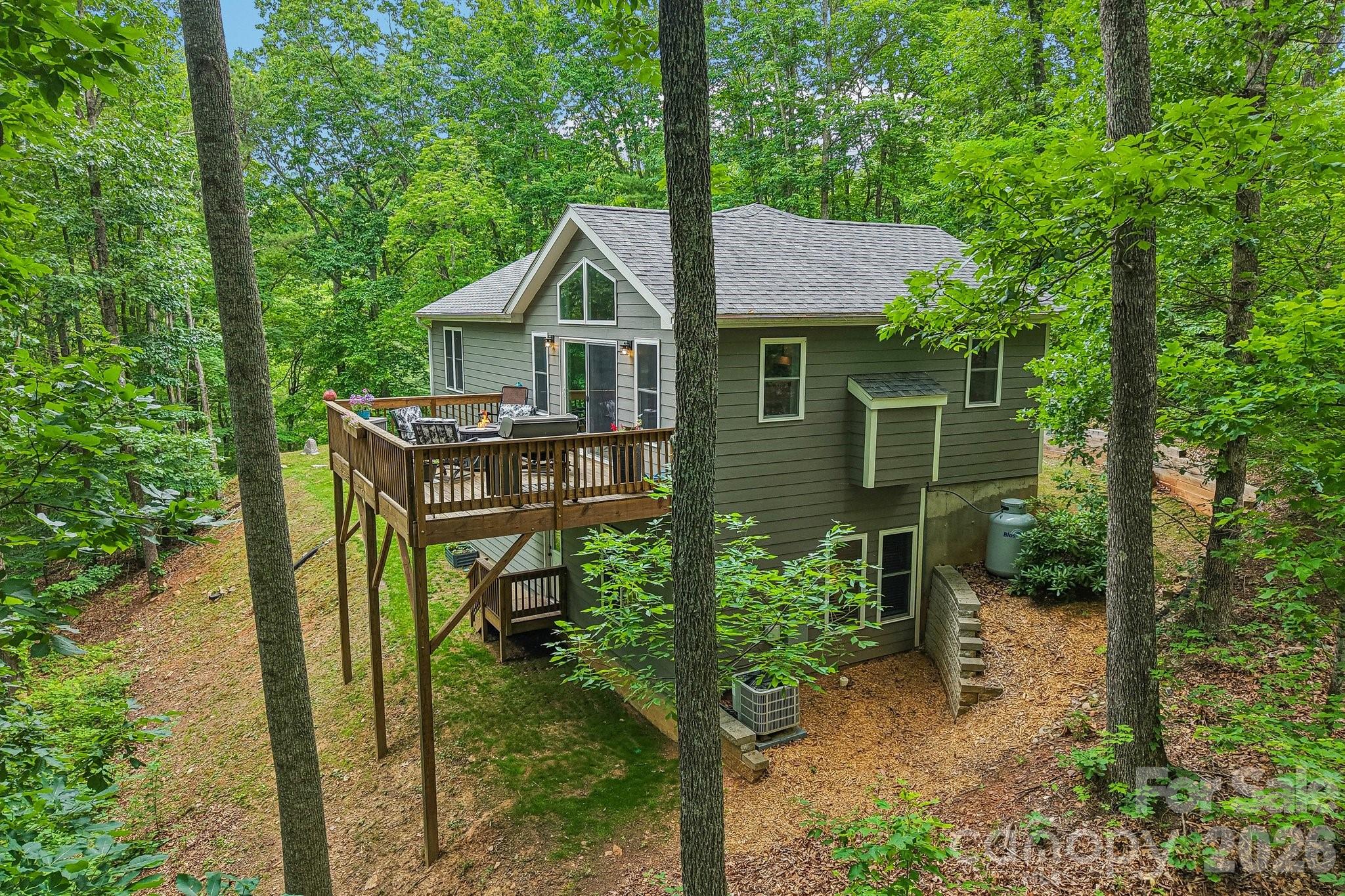 Serenity awaits. You don't have to be isolated to have privacy. This beautiful 2019 build offers privacy with a neighborhood surrounding. Propane fireplace for cozy evenings. Deck overlooking the forest for cookouts and relaxing. Light filled main level perfect for entertaining with open flow kitchen, dining and living spaces. No restrictions on use. Perfect fit for buyers looking for a 2nd home that can be a short term rental as well. Well built and immaculate Candler home with winter views. Open and light filled kitchen, dining and living room. Enjoy the ease of a gas fireplace. Relax on your main level deck overlooking 1.25 acres of forest. Double garage and ample parking. Seller has outfitted the home with a reserve water cistern and UV light filtration system. All the greenery with paved roads and garbage pickup. This home has been very well maintained. Quality construction.