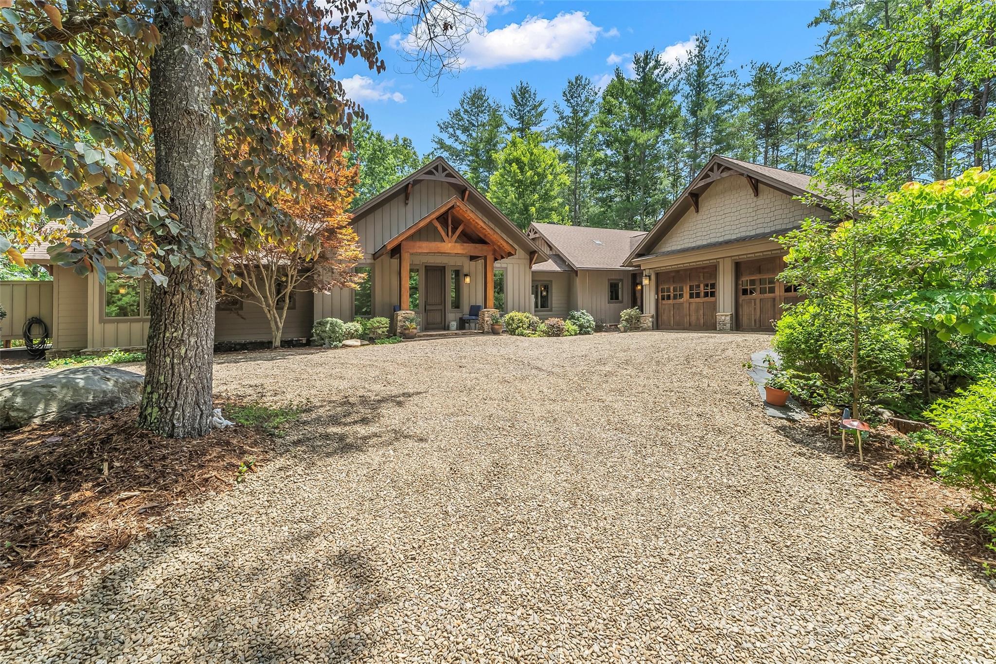 First impressions include a great room with beamed cathedral ceilings, cozy fireplace seating area, open kitchen with large island, SS gas range, wall oven & spacious dining area. Calming view through the trees & long water vistas.  Primary suite w/access to screened porch, office nook & ensuite bath w/soaking tub, large tiled shower or enjoy the private outdoor shower. 2015 built addition connects to the main space by enclosed stone breezeway allowing complete guest privacy. Bedroom, 2nd kitchen, flex space for living room or sleeping quarters with custom Murphy bed. Spacious bath with OS tile shower & large walk in closet & private covered deck off living area.The finished basement has one large room & one private room for additional sleeping areas, lots of storage & a full bath. Detached 2 car garage with covered walkway. Very gentle slope to the lake from house to outdoor fire pit to one slip dock, lift & seating area. Camp Lake James membership included. Can be purchased turnkey.