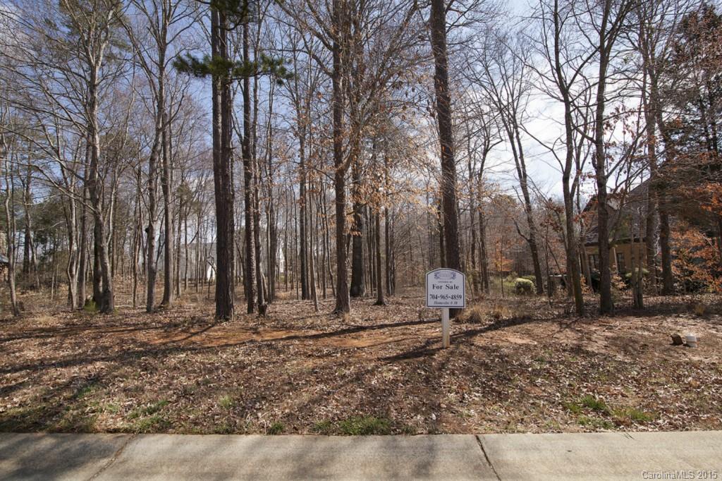 Beautiful wooded lot in community with many amenities such as a Clubhouse, Junior Olympic pool, tennis courts, playground, walking trails, ponds and waterfalls, 40 acres of green space! Low Union County taxes, prestigious Weddington Schools, and so much more!