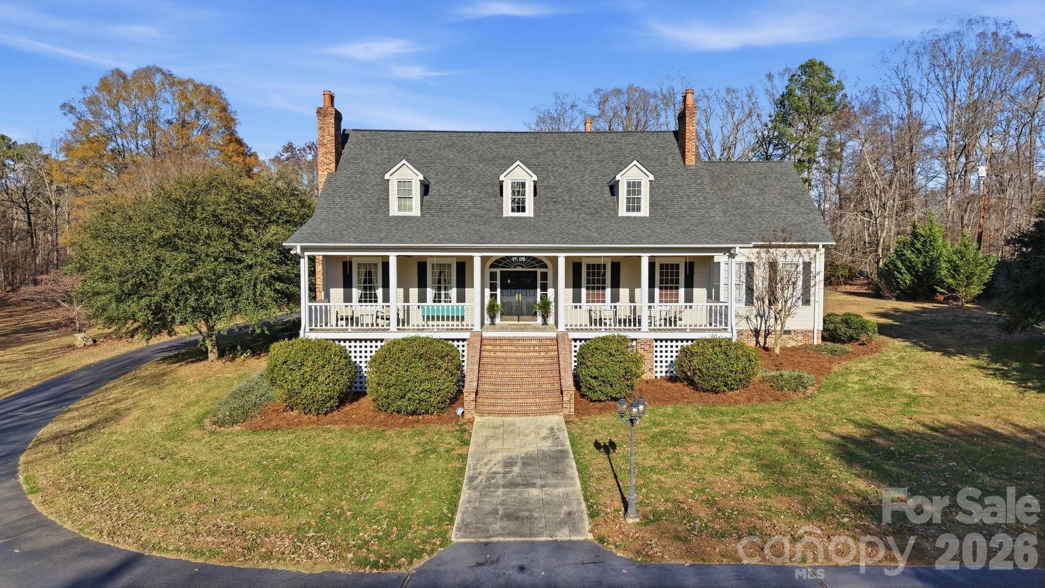Elegant country estate offering 4 bedrooms, 3.5 baths on 1.65 acres, surrounded by a larger parcel with up to 11 additional acres available for purchase from the adjoining property owner—an exceptional opportunity for privacy and expansion.
The spacious main-level primary suite features a private fireplace, oversized bath, and expansive walk-in closet. Rich architectural details continue with a custom library with built-in cabinetry and fireplace, and a formal dining room with fireplace, creating refined yet inviting living spaces.
The kitchen is well appointed with a gas cooktop, wall oven, microwave, breakfast area, walk-in pantry, additional prep sink, and ample storage, opening to a dramatic two-story living room with fireplace and wet bar.
Upstairs offers three additional bedrooms, including one with a private en-suite bath, plus a large bonus room with bar area, ideal for entertaining or recreation. The home provides abundant storage throughout.
Outdoor amenities include a fire pit, pool house, and a former pool area that has been filled in, along with a detached two-car garage and detached carport. A new roof installed in 2021 adds peace of mind. A rare blend of timeless elegance, generous living space, and acreage potential in a private country setting.