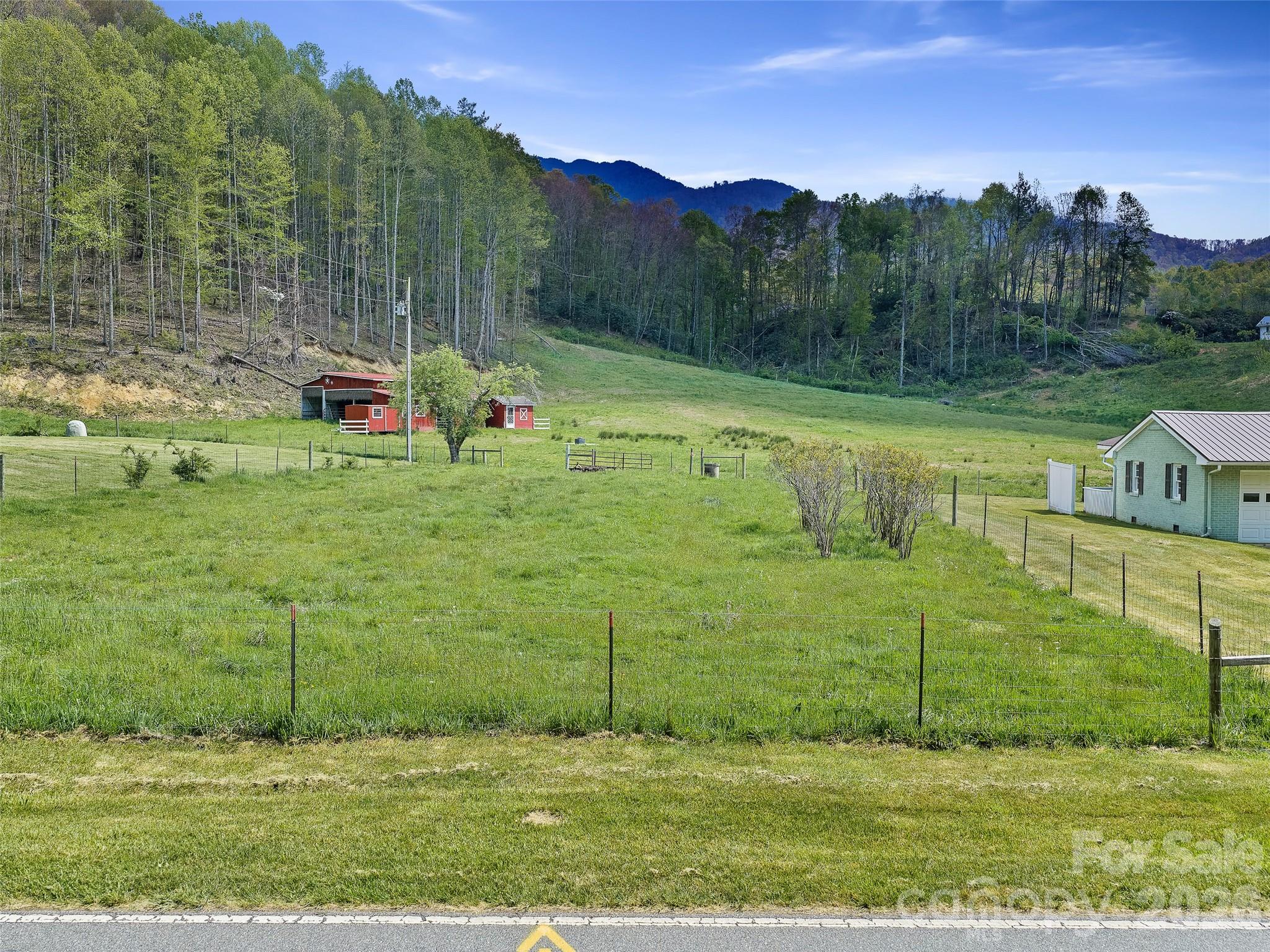 Bring your farm dreams to life with this exceptional 40+ acre property in the heart of the Blue Ridge Mountains! Stay in the small cottage while you build your dream home or just enjoy living small and enjoying large farm land. Located just outside of Bakersville near the Tennessee line, this beautiful tract offers the perfect blend of usability, views, and location. Fully equipped and ready for livestock, the property features a barn, established fencing, and open pasture—ideal for cattle or horses. With great elevation and long-range mountain views, you’ll enjoy both productivity and stunning scenery every day. A mix of usable land and timber adds value and versatility, whether you’re looking to farm, build, or invest. Situated in a great neighborhood with easy access, this property makes it simple to step right in and start farming immediately. If you’ve been searching for acreage that’s ready to go in a prime mountain setting, this is it! Seller is a licensed real estate agent.