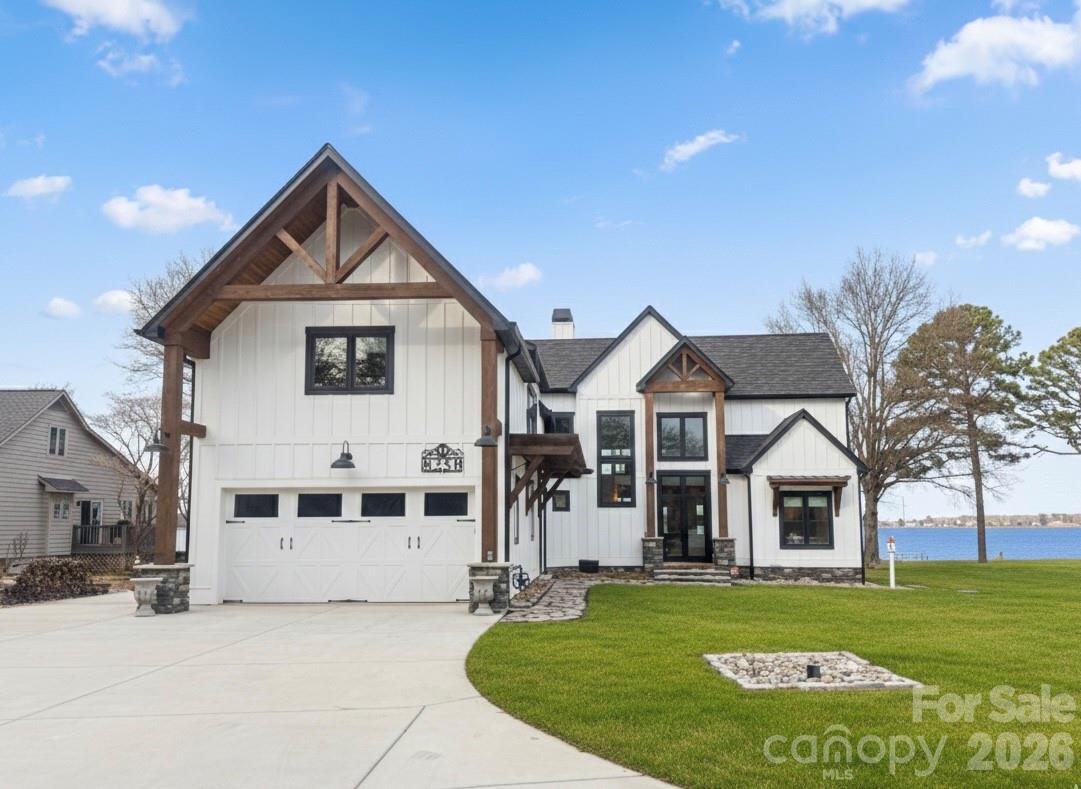 Wake up to wide-open Lake Norman views and end each day with unforgettable sunsets. Perfectly positioned on the main channel in a quiet setting, this custom waterfront home offers the ideal balance of everyday comfort and vacation-style living—whether as a full-time residence or a lake retreat.  Inside, an open, light-filled layout is designed to keep the water front and center. Soaring ceilings, expansive windows, exposed beams, brick accents, and custom built-ins create warmth and architectural interest while framing long lake vistas throughout the main living areas. The home lives primarily as a main-level residence, offering effortless flow for daily living and entertaining.  The chef’s kitchen anchors the space with leathered granite countertops, glass display cabinetry, a butcher block bar, and built-in appliances, highlighted by a statement LeCornue gas range from Paris. A spacious walk-in pantry adds exceptional function with an ice maker, beverage refrigerator, and open shelving—ideal for hosting lake gatherings. The main-level primary suite is a true waterfront retreat, featuring tranquil lake views, dual walk-in closets with direct access to the laundry room, and a spa-inspired bath with soaking tub, dual vanities, and an oversized glass shower. Entertaining flows seamlessly from the kitchen and living areas to the covered patio overlooking the water.  Outdoors, enjoy a resort-style pool, multiple seating areas, and a private dock—perfect for boating, relaxing, and sunset views on the main channel. A standout bonus room offers flexible living as a game room, lounge, or entertaining space, complete with a pool table, bar area, and optional private entrance from the garage. Upper level also features 2 additional bedrooms, 2 full baths, and tons of storage space.  Modern farmhouse style meets elevated lake living, with the flexibility to enjoy now or personalize further. The existing dock may be reconfigured to suit your preferred waterfront setup. New walk-way installed at front door and from the patio to the dock.  Conveniently located near Denver, Mooresville, Huntersville, and Charlotte Douglas International Airport, this is Lake Norman living defined by views, access, and ease.