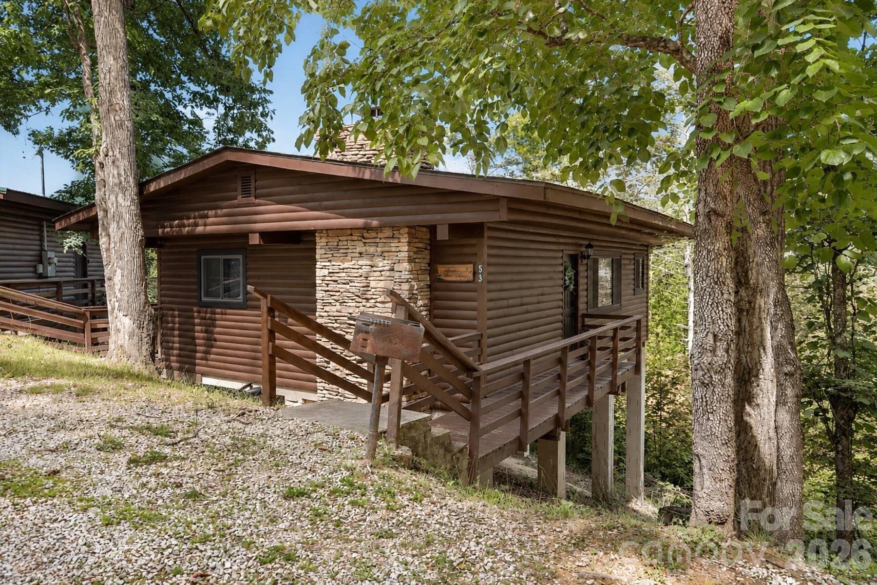 Welcome to your perfect mountain retreat in Nantahala Village! This charming 2-bedroom, 1-bath cabin offers a blend of comfort and convenience, featuring low-maintenance living so you can spend more time enjoying the beauty around you. The cabin comes fully furnished with pine flooring, tongue-and-groove walls and ceilings, and a stone wood-burning fireplace for cozy evenings. The kitchen is equipped with stainless steel appliances, and a large picture window frames serene wooded views from your end-unit location—providing added privacy and tranquility. Enjoy resort-style amenities including tennis courts, a pool, and a fitness center. With easy paved access, you’re just minutes from Bryson City and the scenic Nantahala Gorge. Move right in and start living the mountain lifestyle you’ve always dreamed of!