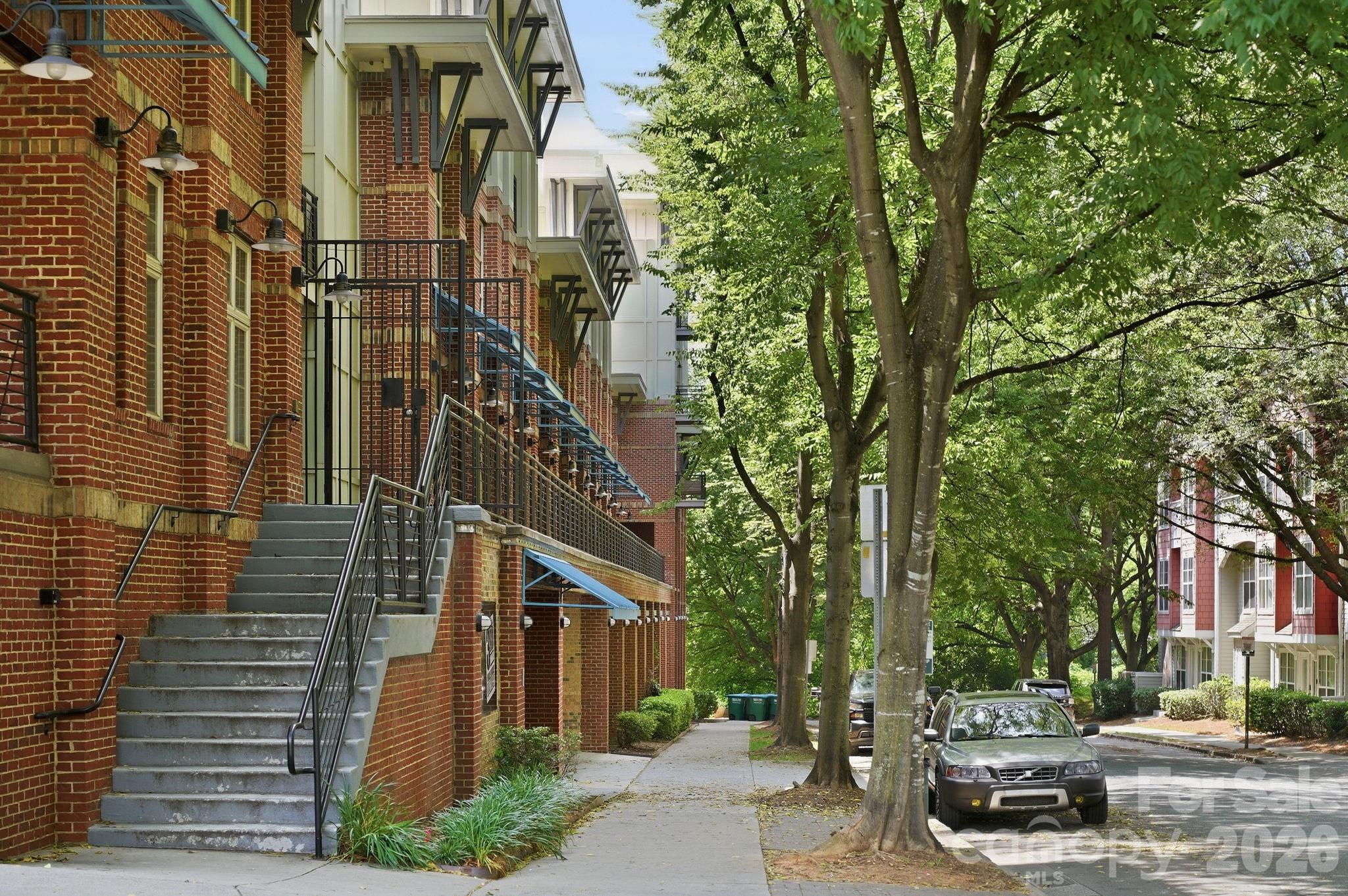 Located in the heart of Third Ward and truly walkable to Uptown, this top-floor, 2-bedroom, 2-bath corner condo offers an easy city lifestyle with thoughtful conveniences. Enjoy quick access to Panthers, Charlotte FC, and Knights games, the greenway, restaurants, coffee shops, and all that Uptown has to offer.
Inside, the bright and open layout is filled with natural light from large windows and offers an easy flow between the kitchen, dining, and living areas. Recent updates include new lighting in the kitchen and dining area, fresh paint and new flooring installed in 2025, and a newer HVAC system for added peace of mind. The covered balcony overlooks Frazier Park—an ideal place to enjoy morning coffee or unwind at the end of the day. Mature trees along the edge of the community create a welcome sense of privacy just minutes from the energy of the city.
A desirable split-bedroom floor plan offers two comfortable bedroom suites, each with a walk-in closet and private en-suite bath. The unit includes a refrigerator,  newer washer, and dryer for added convenience. Located in a secure elevator building with key fob access and gated garage parking, this home also includes one dedicated parking space plus a deeded storage locker in the parking deck—an increasingly valuable feature for condo living.
Residents can enjoy the interior courtyard with grills, gathering areas, and skyline views, while city park offers a playground, dog park, walking trails, tennis courts, and basketball courts just steps away. This property has been a steady long-term rental for the current owner, making it an appealing opportunity for an owner-occupant or investor seeking a well-located Uptown condo.