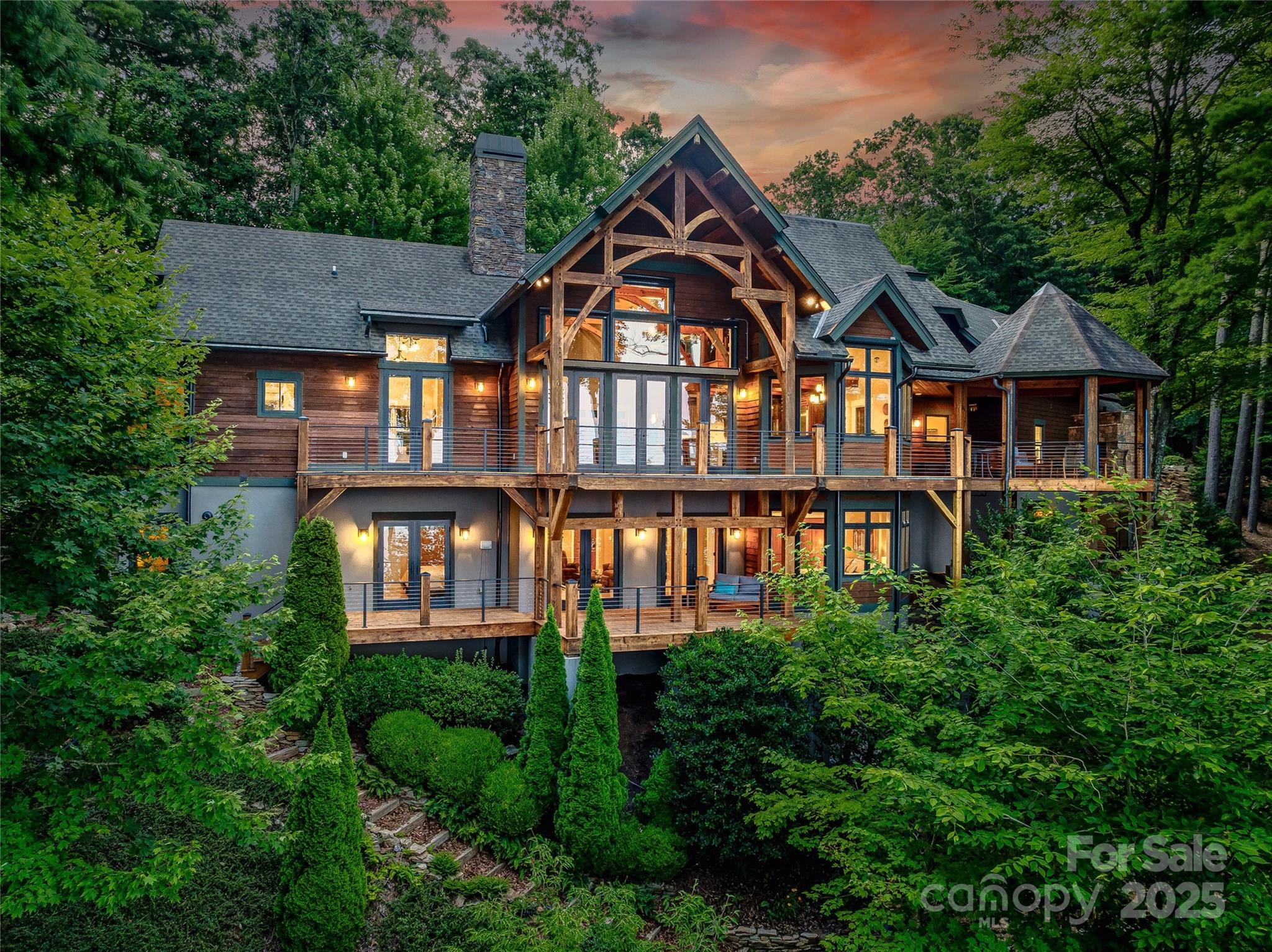 This setting is one of the reasons so many want to live in WNC and this is a lifestyle move.  Located in a gated community this Custom Built Timberframe home w/ quality finishes lives beautifully inside and out. One in a Million long range west facing MTN views w/ easy access and minutes to downtown AVL or N.AVL. These sunsets will take your breath. 26 ft ceilings at the entry w/ a wall of windows framing mountain views all day long. This home was designed to capture views throughout the home. Outside: open and covered decking, retractable awnings, gazebo w/fireplace, pathways/trails, and native plantings. Inside, an explorer’s loft, an artist’s studio, a cook’s kitchen, w/ a primary suite that is due west w/ a jetted tub. SO much flex space to carve out suiting your specific desires.Lower level guest area w/ fireplace and media room. This place is showing off nature at every turn yet so close to mountain city life. See Video in MLS & features & more. 5.08 Acres w/ a res build lot.